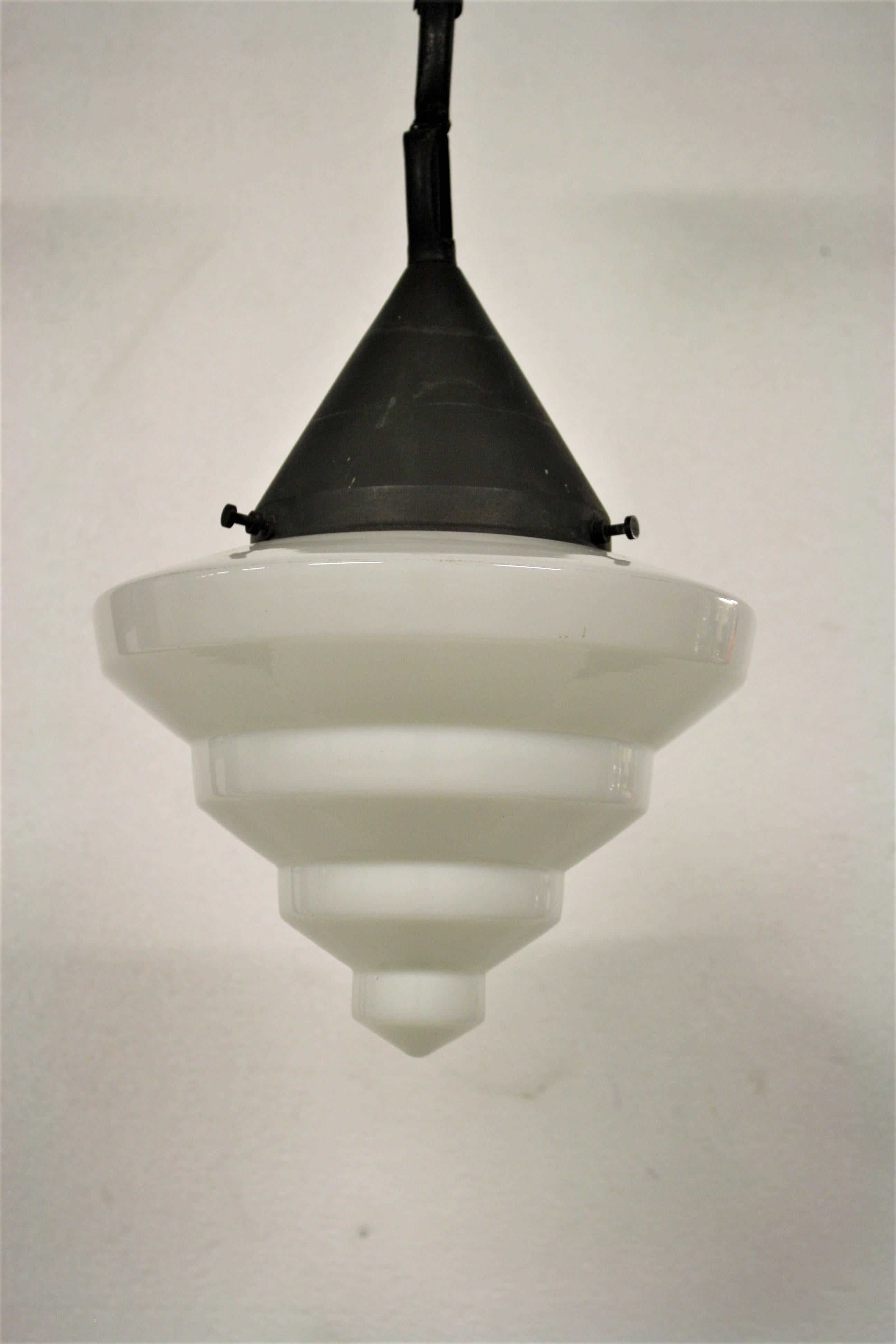 Antique conical Art Deco era opaline pendant light.

The lamp has a typical stepped Art Deco design pattern.

Supplied with origanl chain and shade holder.

Rewired, tested and ready to use with a regular E27 light bulb.

1930s,
