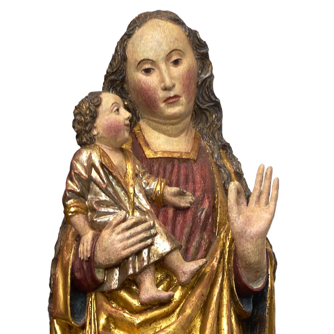 A lower Rhine figure 'fourth quarter of the 15th century' of the Virgin and Child, finely carved in half round, the Virgin depicted standing in slightly contrapost, with fine facial features and long curly hair running over her shoulders , wearing a