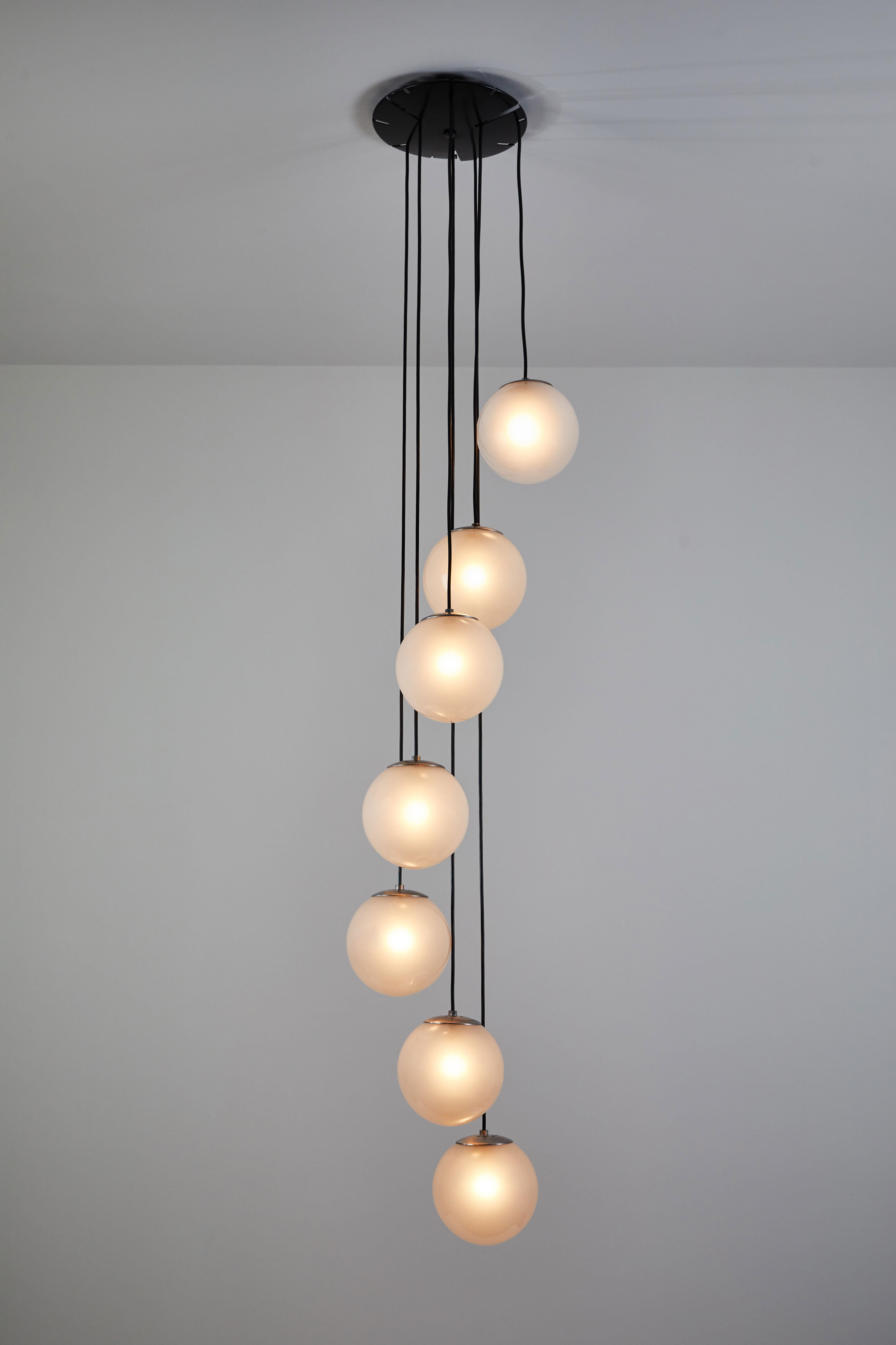 Model 2095/7 seven globe chandelier by Gino Sarfatti for Arteluce. Designed and Manufactured in Italy, 1958.
Aluminum, glass, enameled metal, cloth cord. Rewired for US junction boxes. Each globe takes one E14 25w
maximum bulbs. Literature: Gino