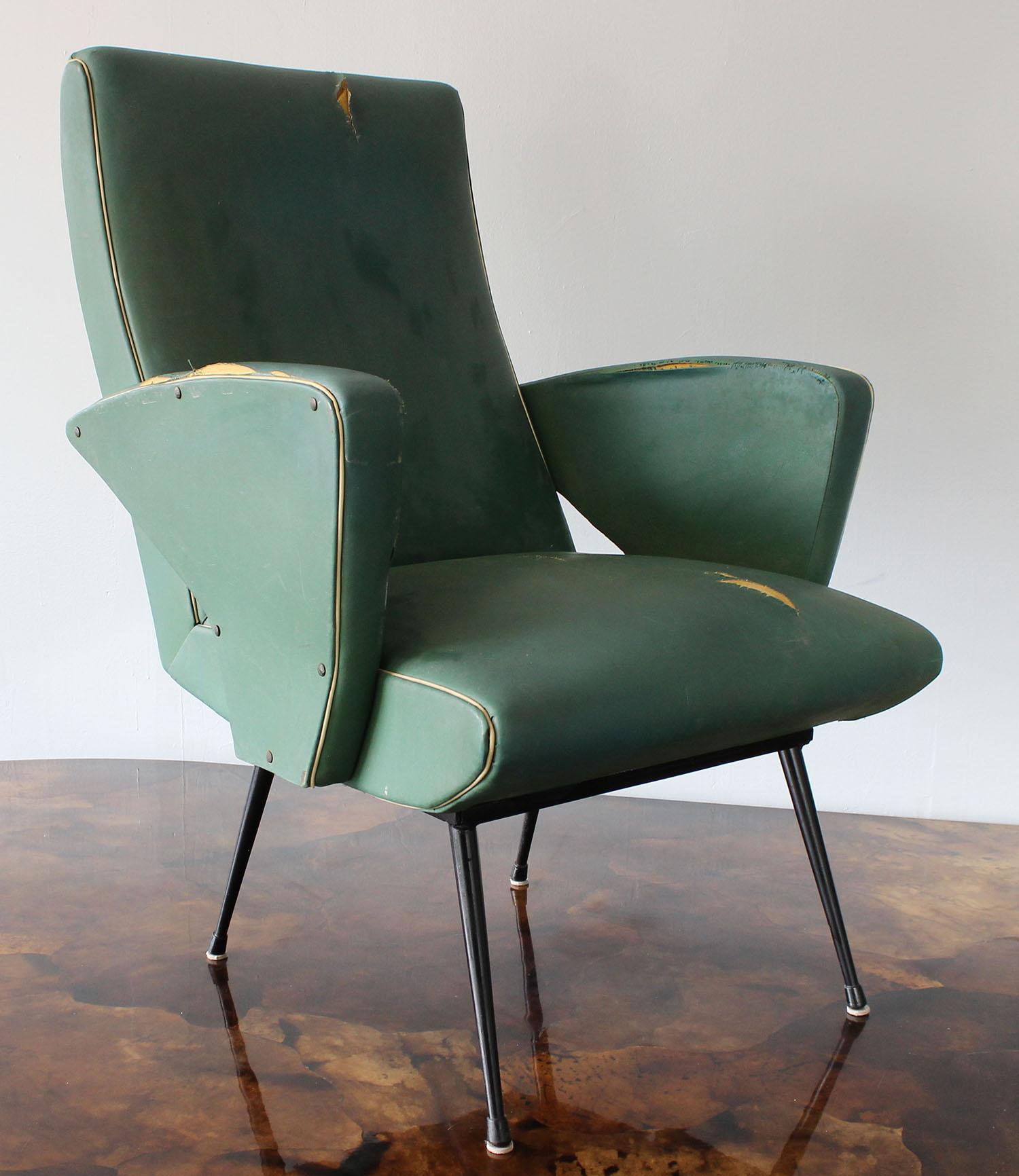 A midcentury Italian armchair with boomerang arm detail. In original faux leather upholstery.
Arm height 22 inches.