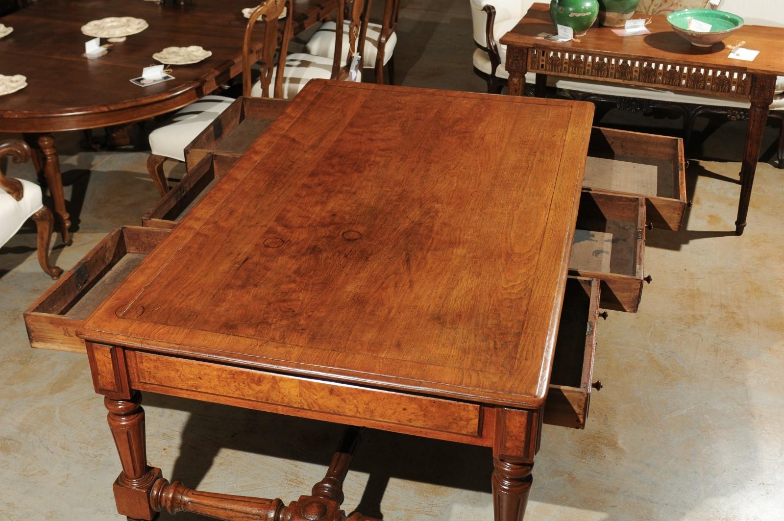 A 19th century American walnut partners desk with six drawers, turned baluster legs and cross-stretcher. This American partners desk features a rectangular framed top sitting above six exquisite drawers each adorned with two wooden pulls. The desk