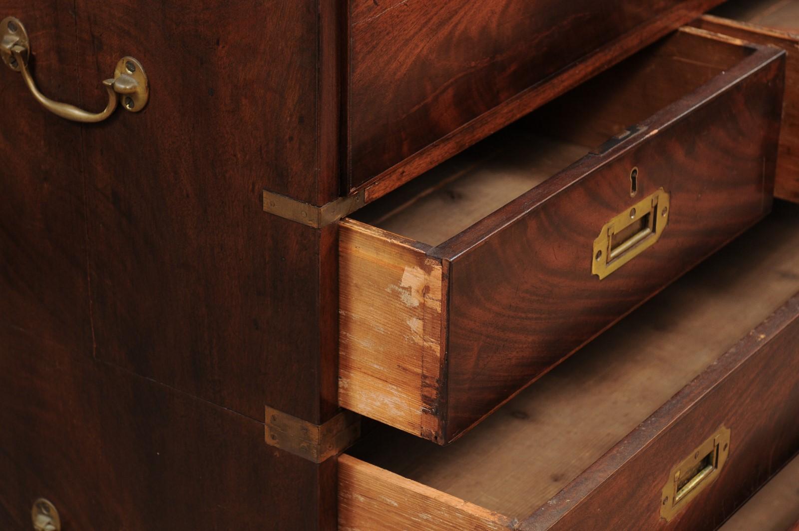 The 19th century English mahogany Campaign style chest with secretary drawer above four drawers with brass pulls, brass handles and banding on the sides. All resting on bracket feet.













    