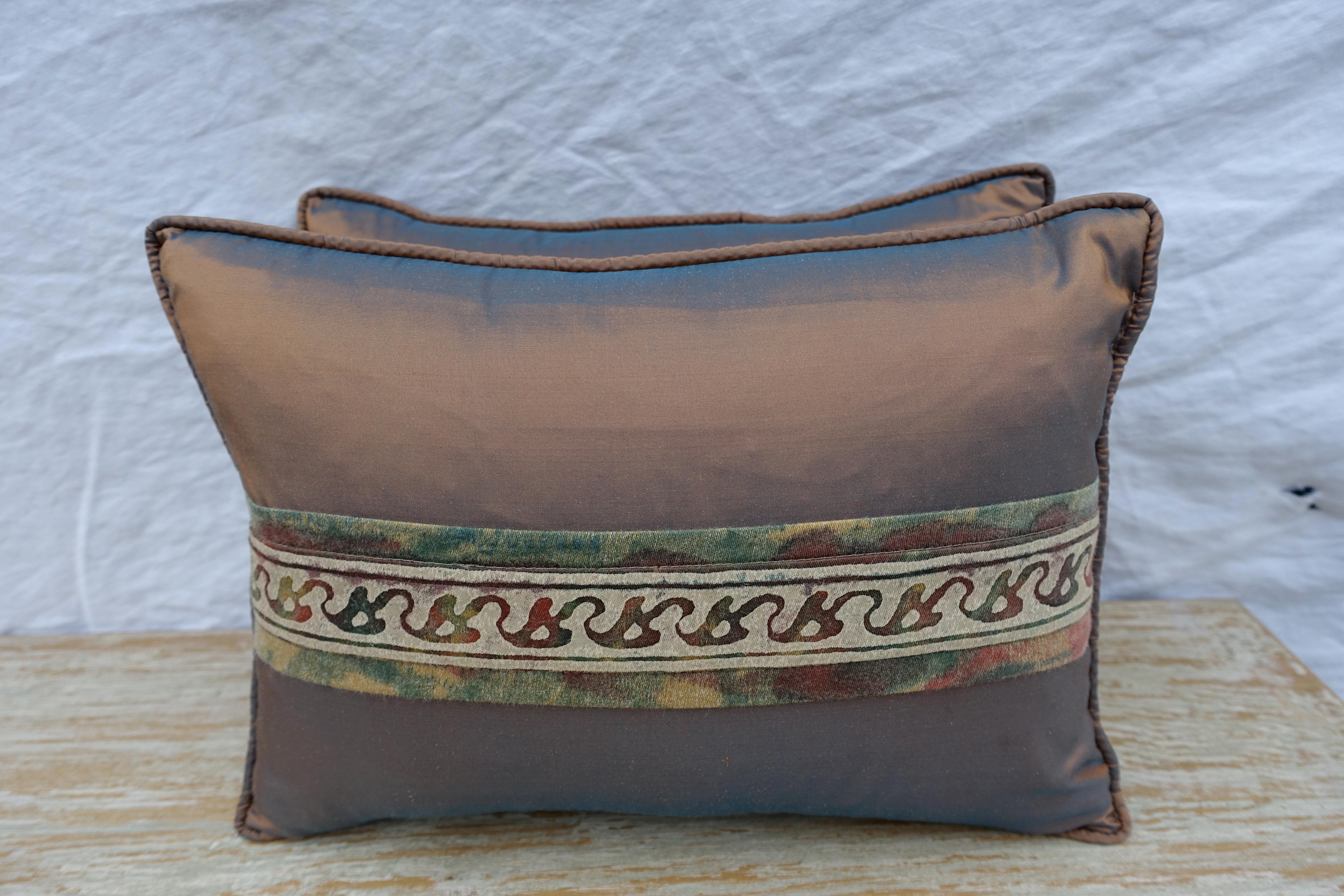 Pair of custom pillows made with vintage fortuny textile border combined with contemporary copper colored silk taffeta. Self cord detail. Down inserts, sewn closed.