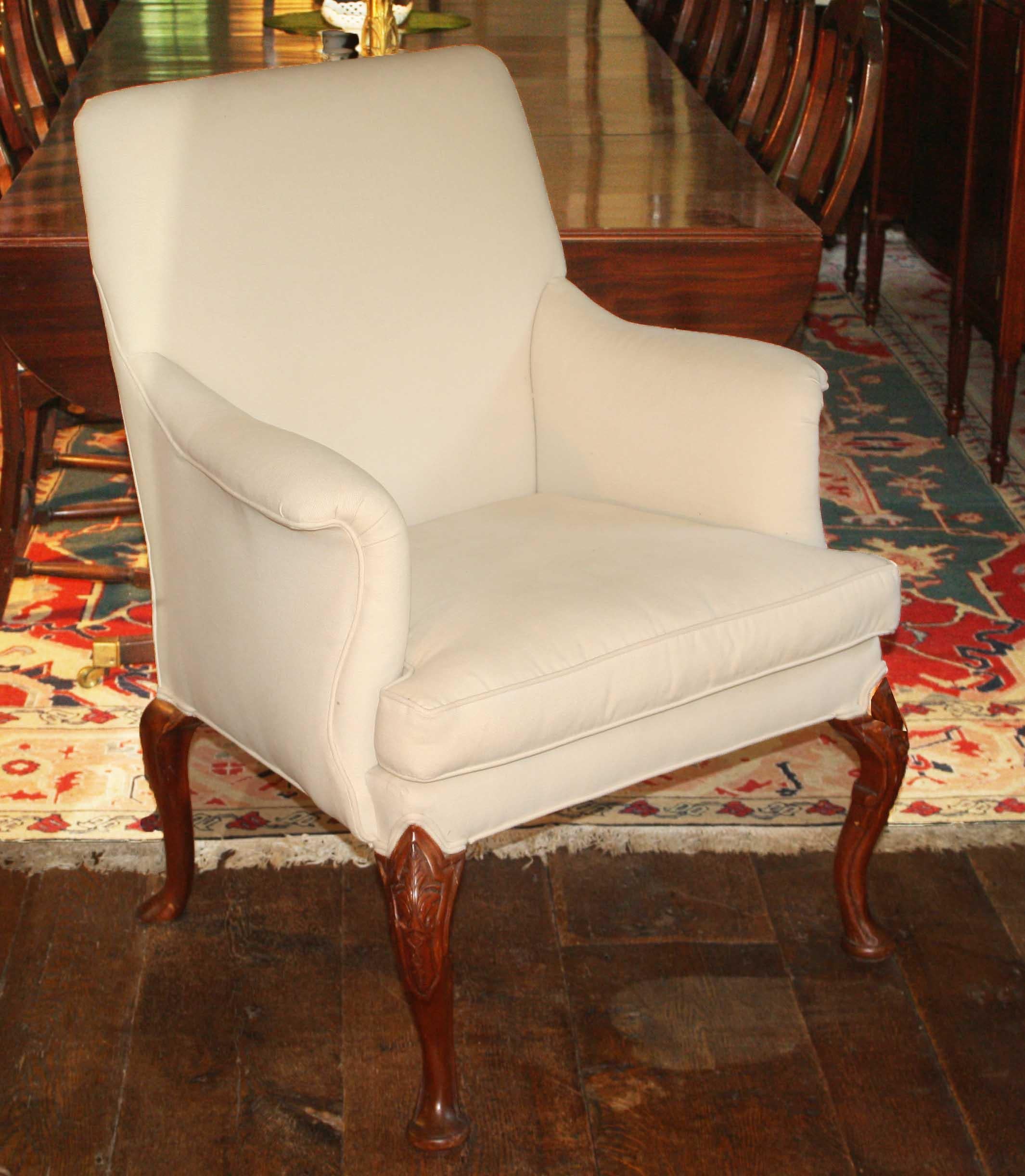 An English upholstered armchair from the later years of the reign of George II, circa 1750.
Particularly refined shape and proportions to the upholstered structure, with a removable
cushion seat.  Intricately carved walnut cabriole front legs and