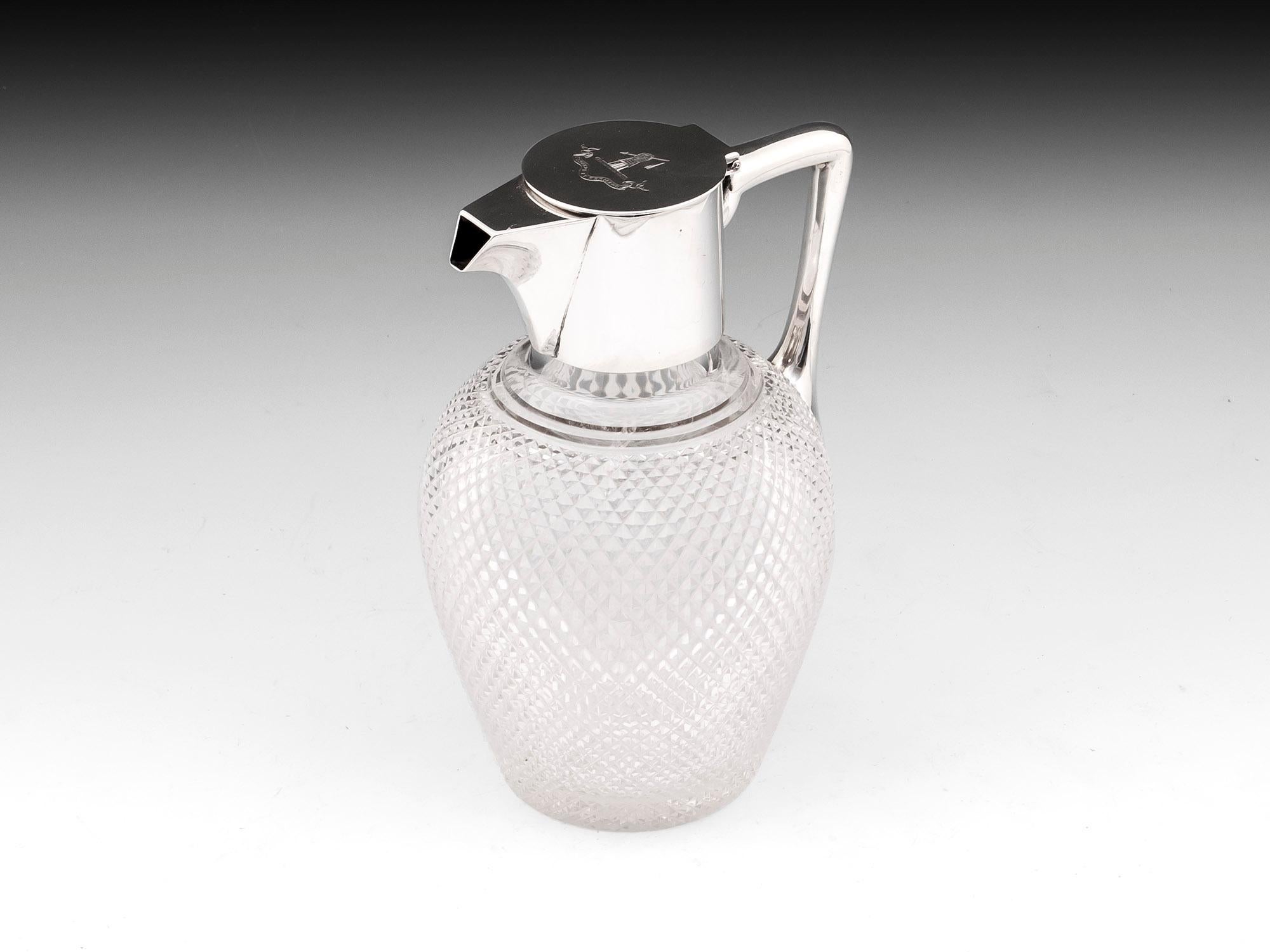 Glass claret jug with star cut base and sterling silver top by Birmingham silversmiths Hukin & Heath. With an engraved Harrison family crest on the lid which reads:
Ferendo et Feriendo with translates to 