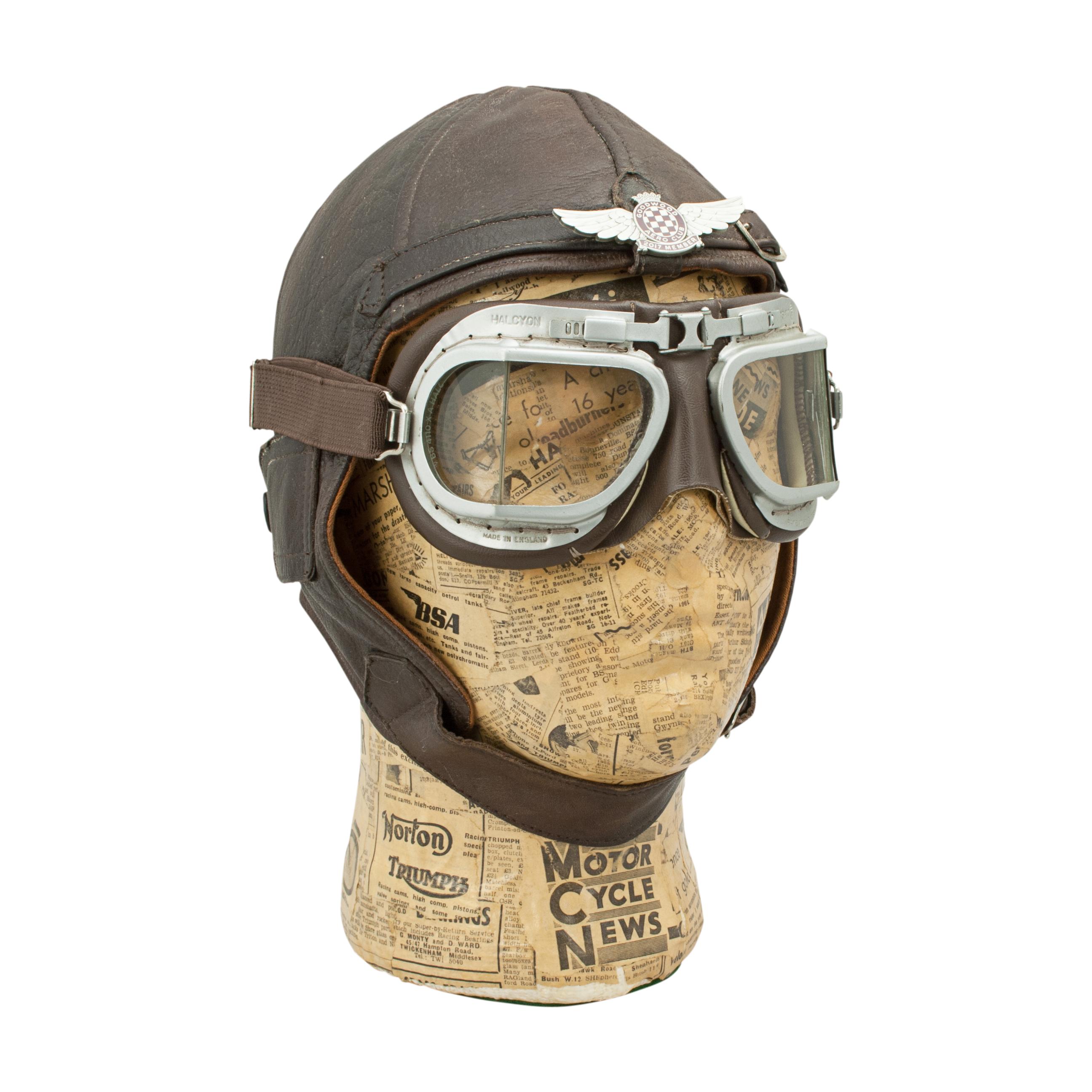 Leather Flying Helmet.
A lightweight leather flying helmet made from supple dark brown leather with a brown cloth lining. The WWII style leather aviator pilots cap has covered earflaps with popper fastening, goggle loop at the rear, adjustable