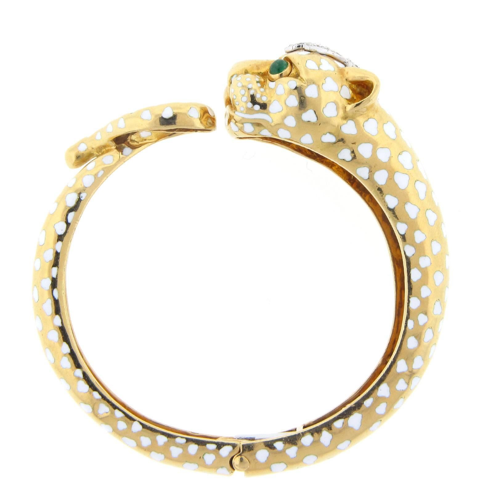 Vintage David Webb Panther Collection bangle. The bangle is made of 18K yellow gold and weighs 38.80 DWT (approx. 60.34 grams). It also has eight round G-color, VS-clarity diamonds weighing 1.00 CTTW, and two cabochon emeralds.