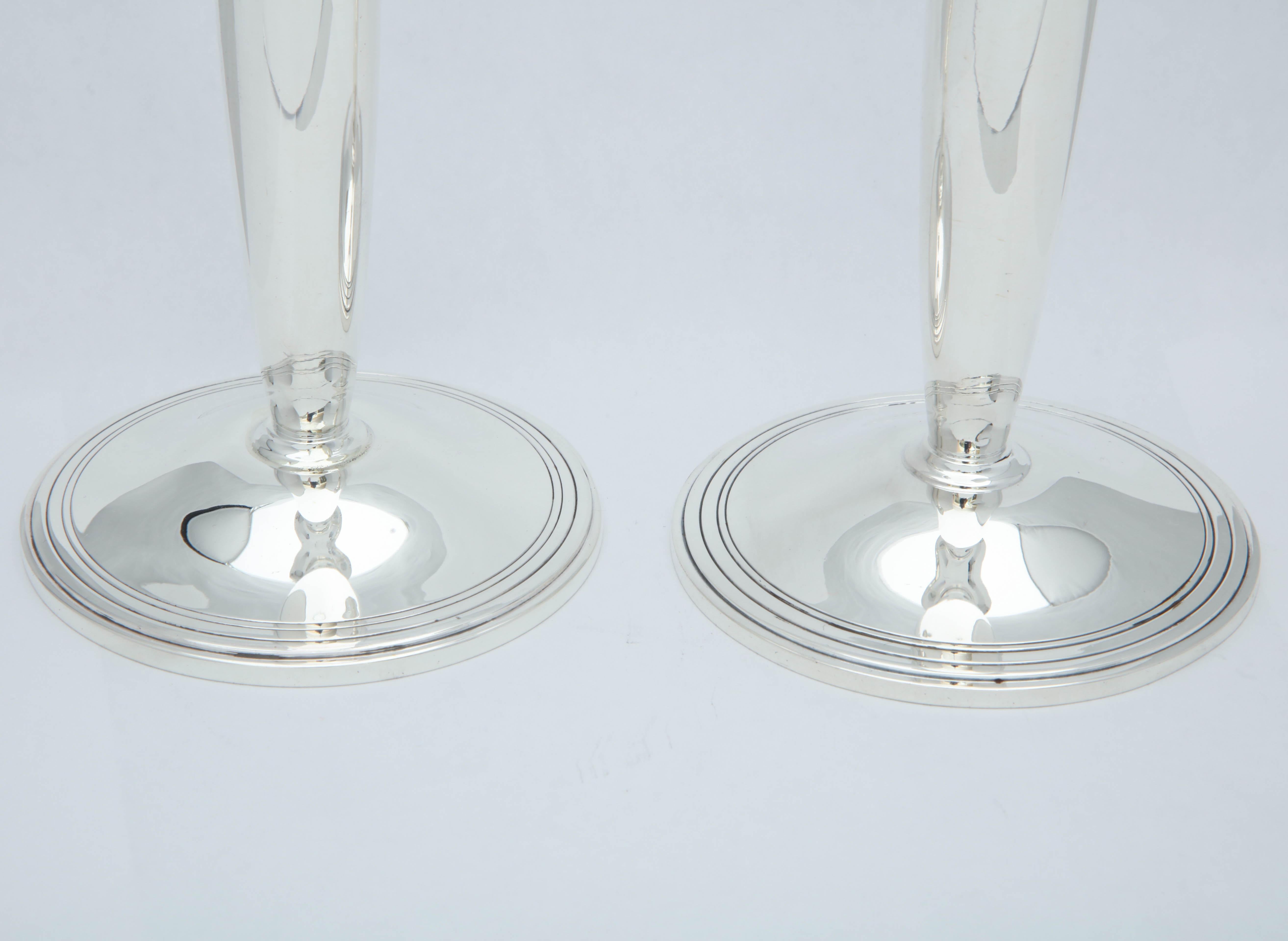Pair of sterling silver, Mid-Century Modern candlesticks, Tiffany & Company, New York, year marked for 1949-1950. Each measures 7 3/4 inches high x 3 3/4 inches in diameter across base. Pair weighs 12.250 troy ounces. Dark spots in photos are