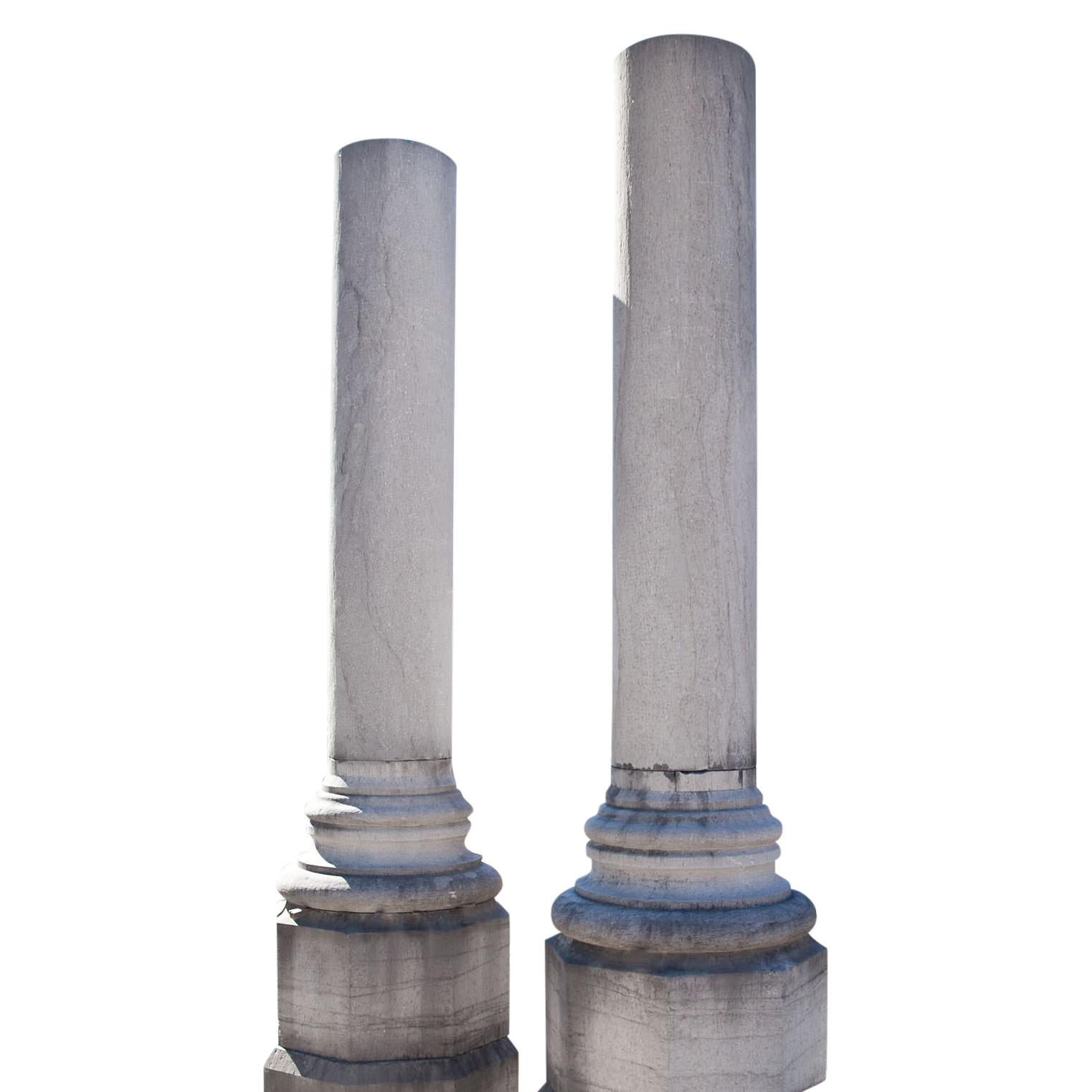 Paire de colonnes monumentales sur des piédestaux polygonaux avec des bases rondes et des fûts lisses. 