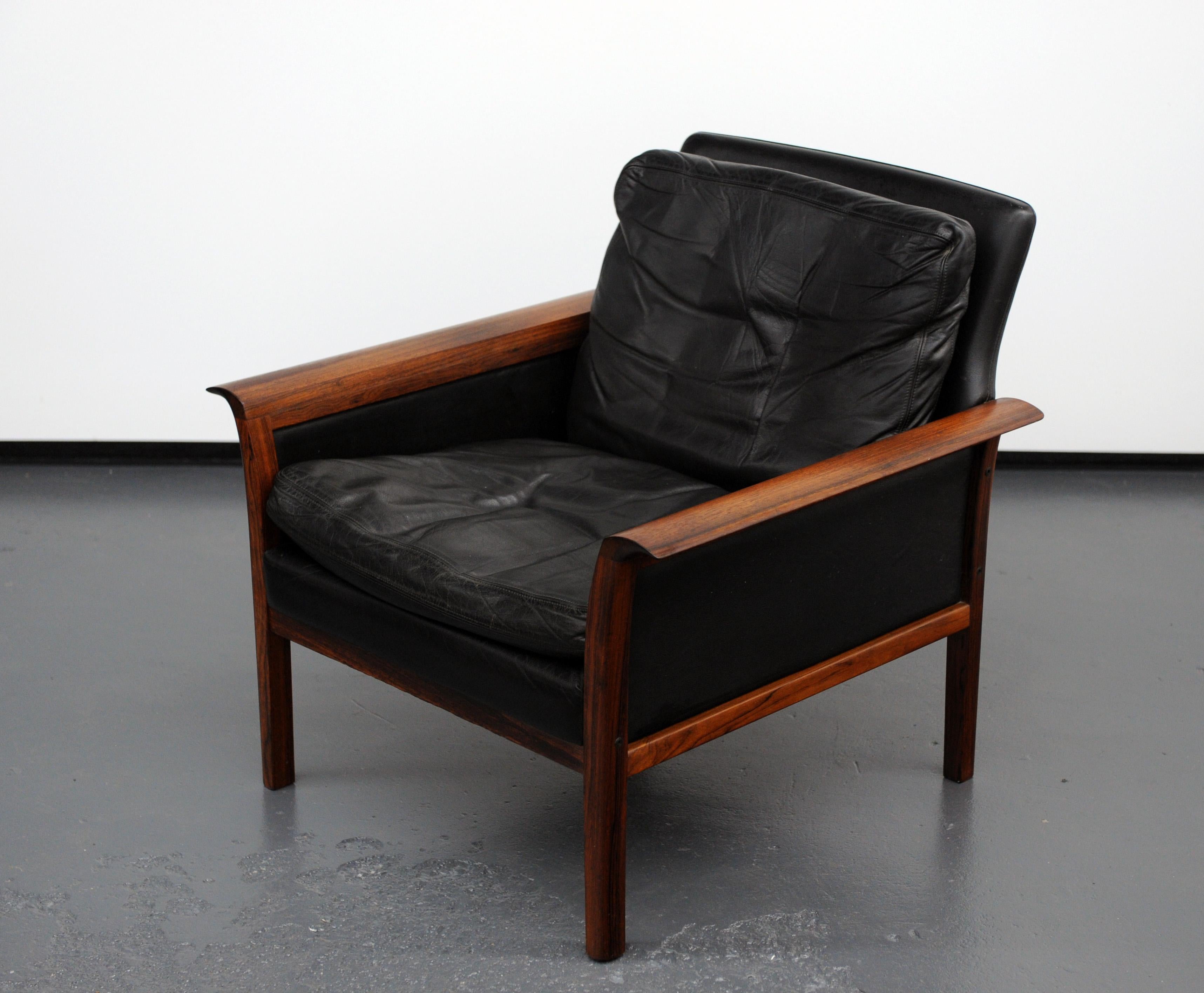 Appealing leather lounge chair will solid rosewood frame. Desirable design with beautiful curved rosewood armrests. Manufactured in the 1960s by Vatne Møbler of Norway, label to underside. Soft black leather with original down feather pillows.
 