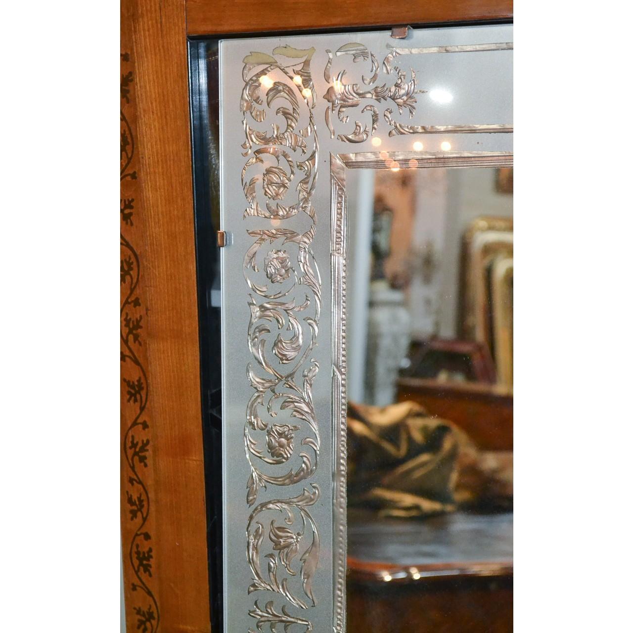 Uniquely designed Venetian glass reverse painted wall or console mirror. The border finely decorated with stylized leaves, flower heads and blossoms, circa 1940.