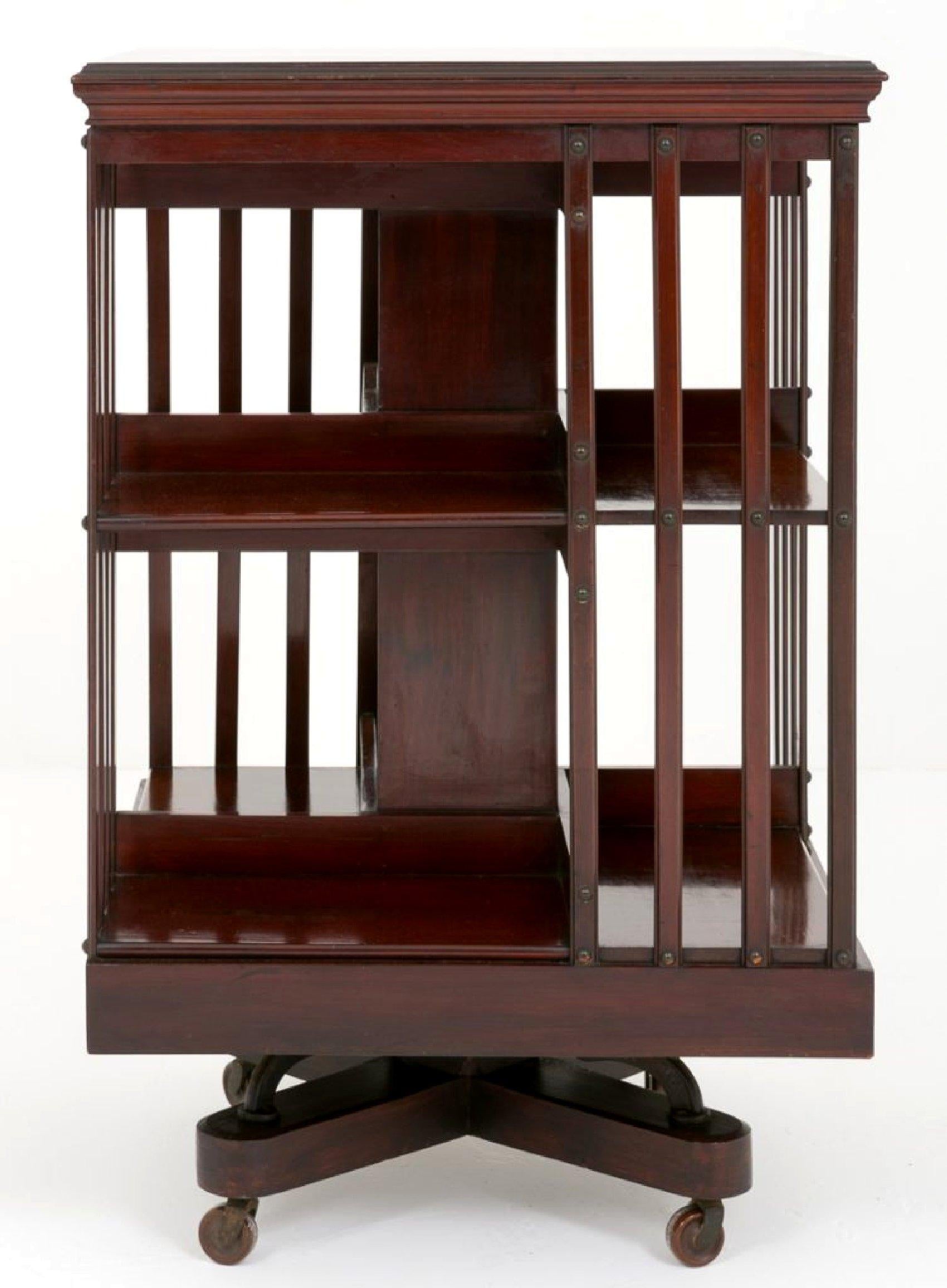 This outstanding 19th century mahogany squared side table features a central shelf with slat detailing on all 4 sides. The unit revolves and is supported on a short X-frame base and finished with porcelain castors. It would be ideal for a bookcase