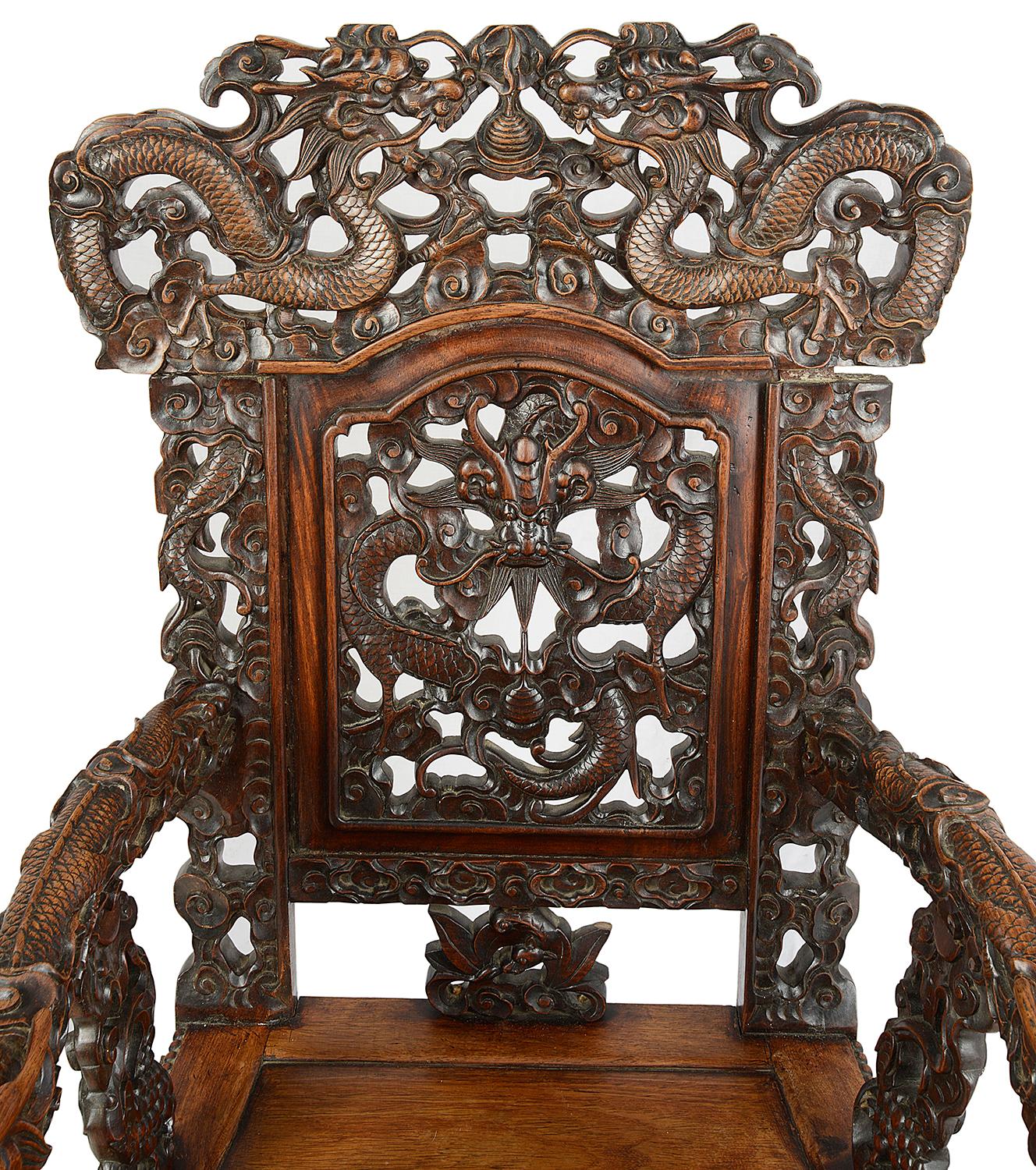 A fine quality 19th century Chinese hardwood armchair, having wonderfully carved mythical dragons to the backrest and arms, clouds, scrolling foliage and Bats, an inset panel to the seat and raised on shaped front legs terminating in ball and claw
