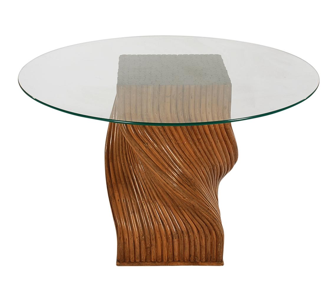 A very neat spiral dining table, circa 1970s. It consists of walnut stained bamboo in a spiral formation with a heavy glass top. In very good well cared for condition.