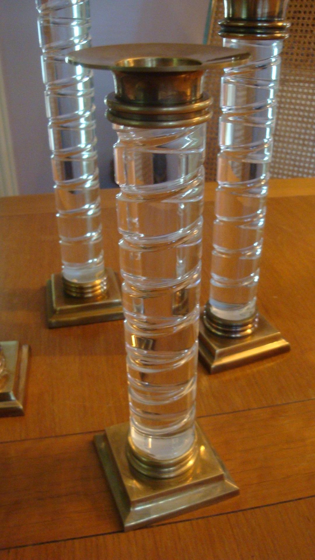 This is a set of four Dolbi Cashier Lucite and brass candlesticks from 1987. The set is in excellent condition and range from 9-13 inches in height.