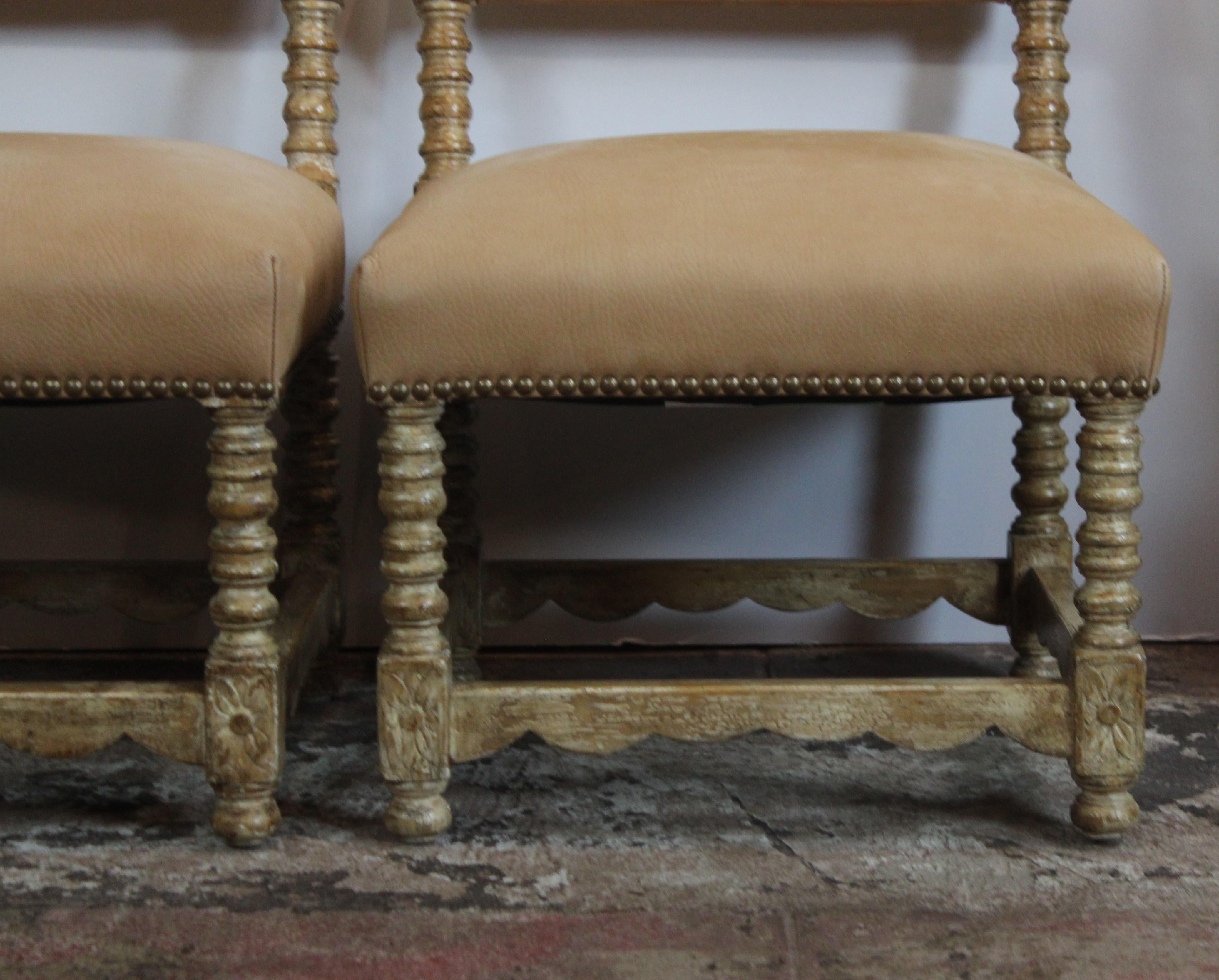 Pair of low Spanish style chairs. Carved wood frame. Upholstered in suede.