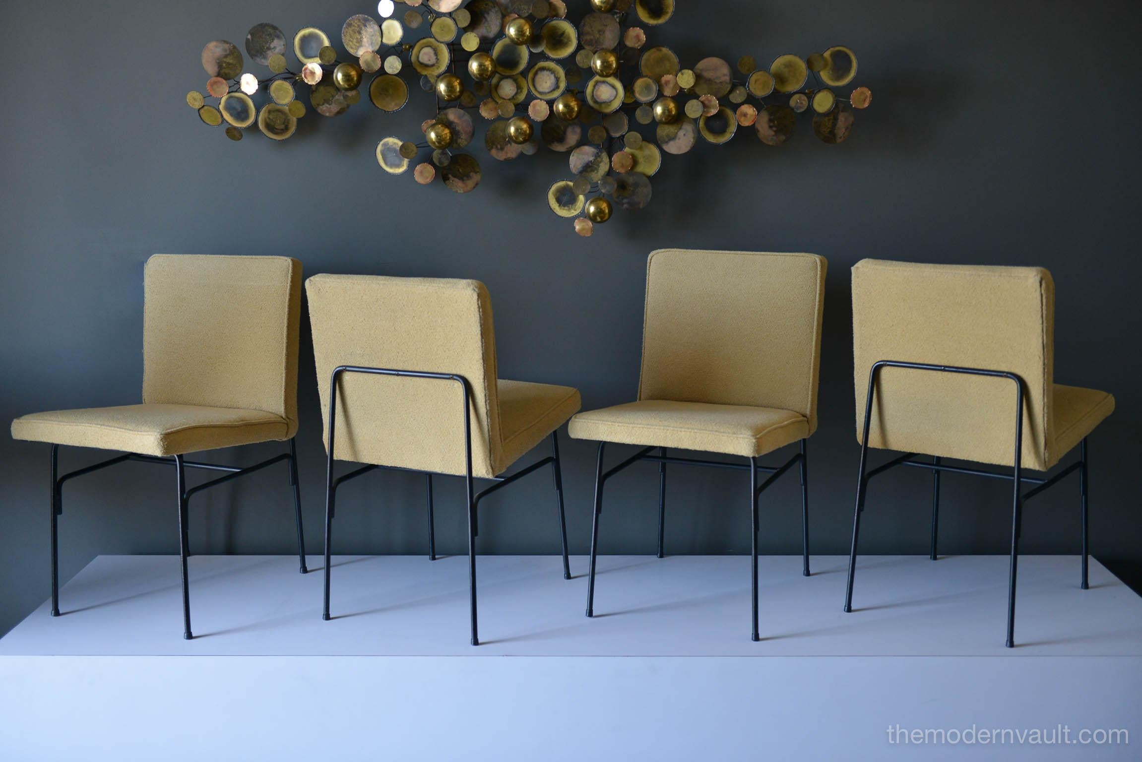 Set of four iron dining chairs by Allan Gould, circa 1955. Iron is in excellent vintage condition with no rust. Mustard color wool bouclé upholstery is in good condition. Easily recovered in a fabric of your choice.

Measures: H 30 in. x W 16 in.