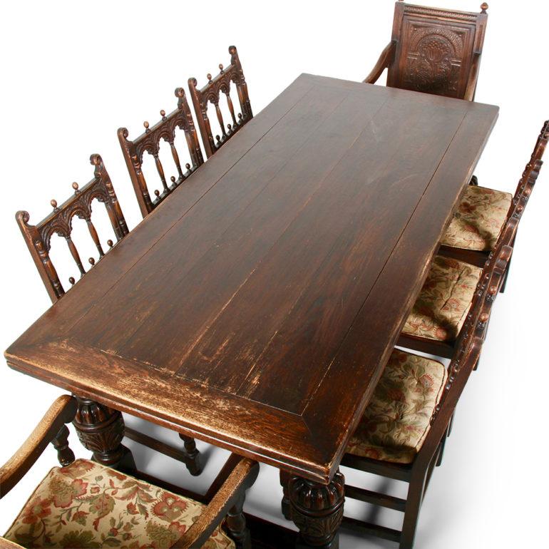 A large, American-made, solid oak Renaissance Revival drawleaf dining table with boldly-carved gadrooned apron and carved legs, the solid plank top extending to a generous thirteen feet when extended.

Original labels on all pieces-  Kensington