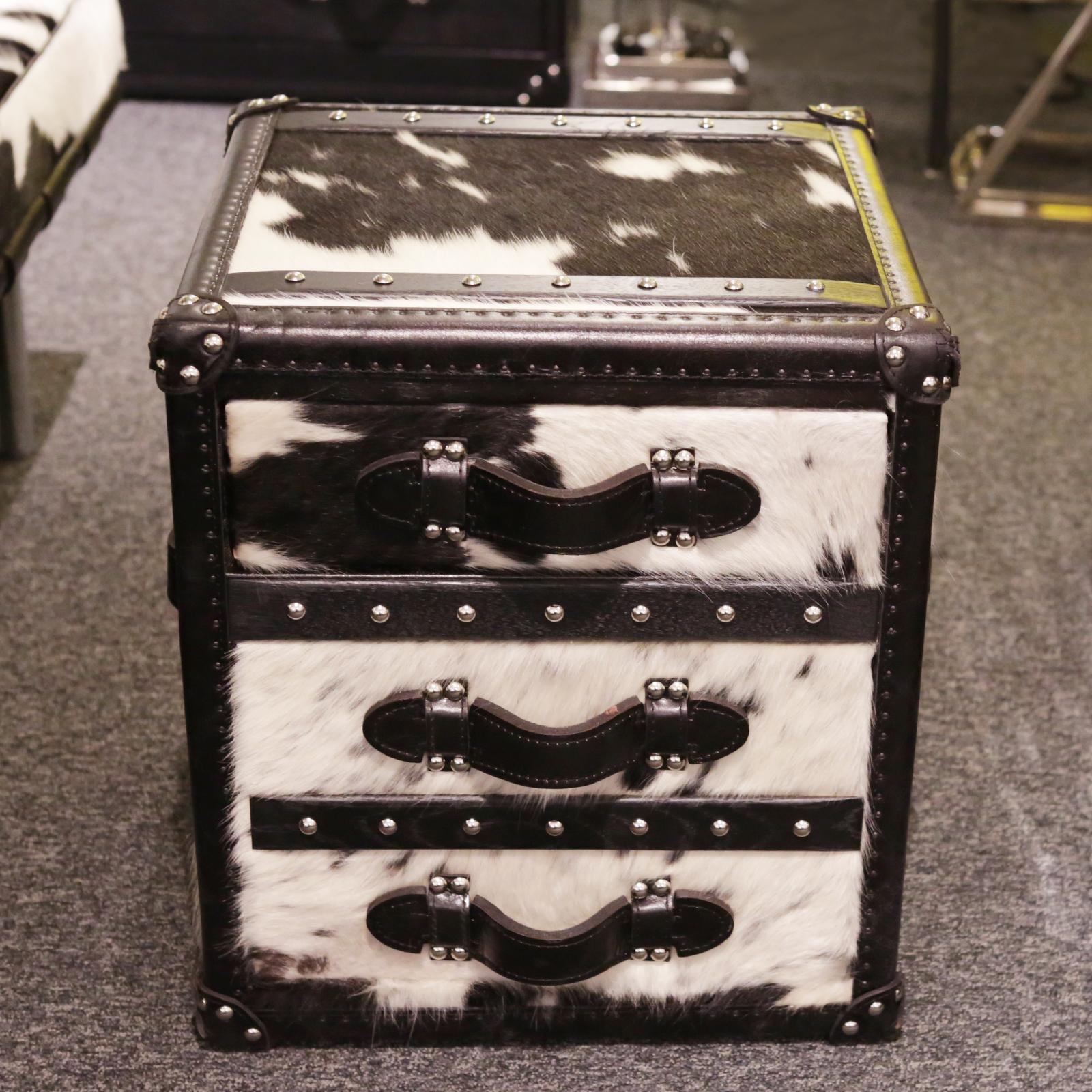 Wild black and white cowhide cube chest
with structure in solid wood and covered with 
natural black and white cowhide. With black
genuine leather handles and with polished 
stainless steel nails. With three drawers with black 
fabric inside.