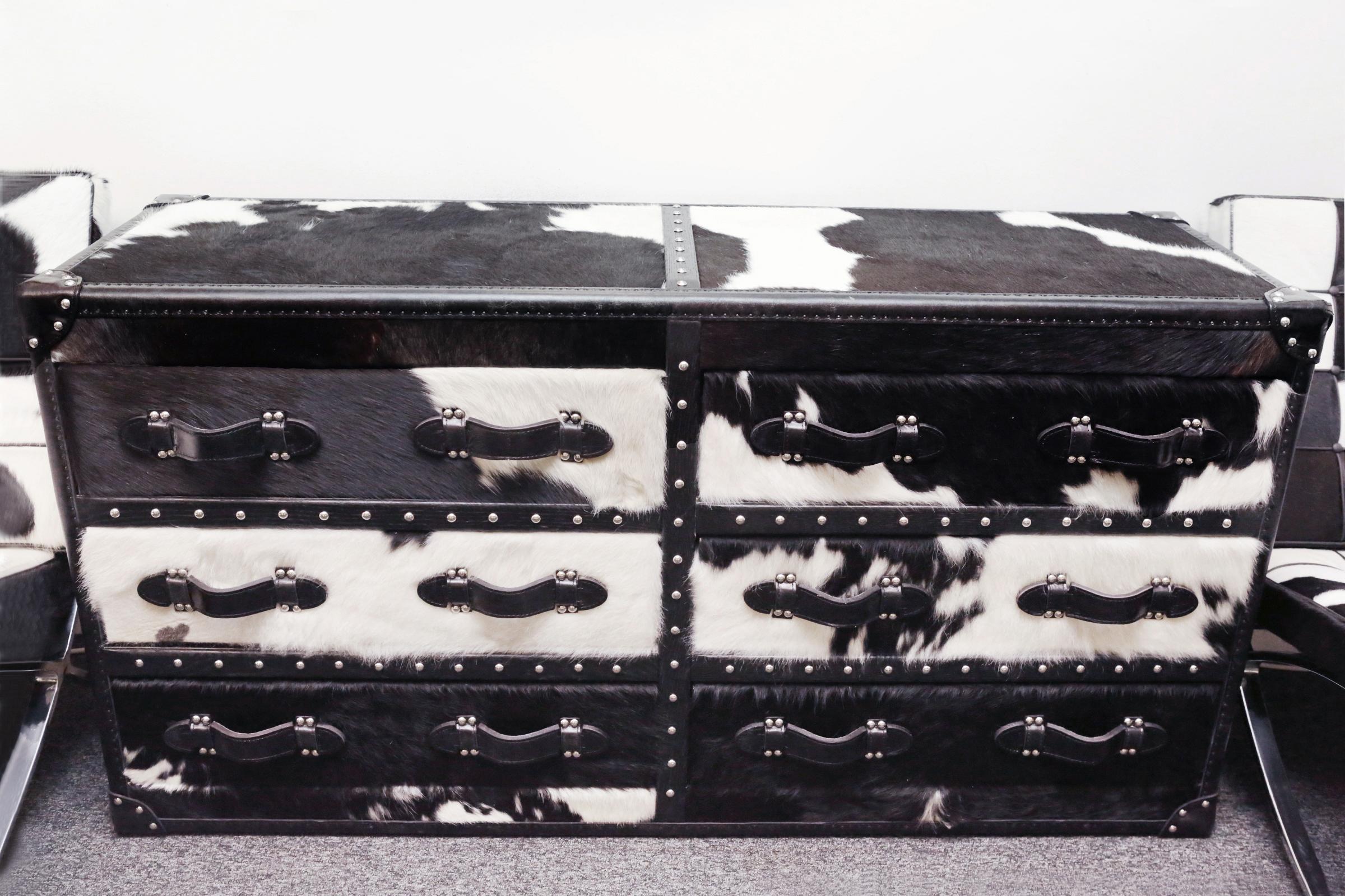 Wild black and white cowhide long chest
with structure in solid wood and covered with 
natural black and white cowhide. With black
genuine leather handles and with polished 
stainless steel nails. With 5 drawers with black 
fabric inside.