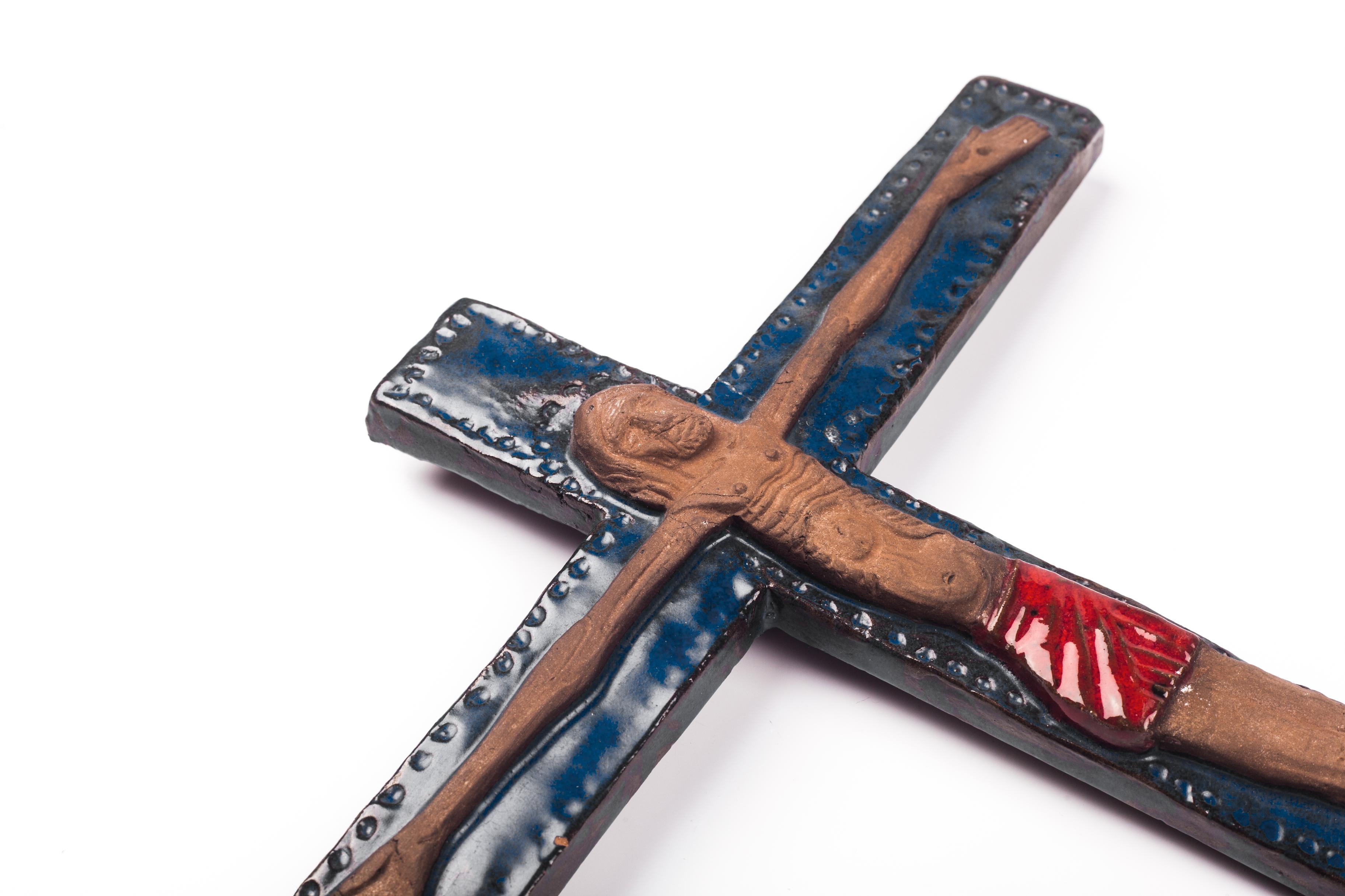 Large glazed wall cross in Klein blue with a red swathed Christ figure in matte clay. This is a handmade one-of-a-kind piece that was part of a large collection of Belgian crosses made by artisan potters in the 1950s-1970s. A unique decorative item