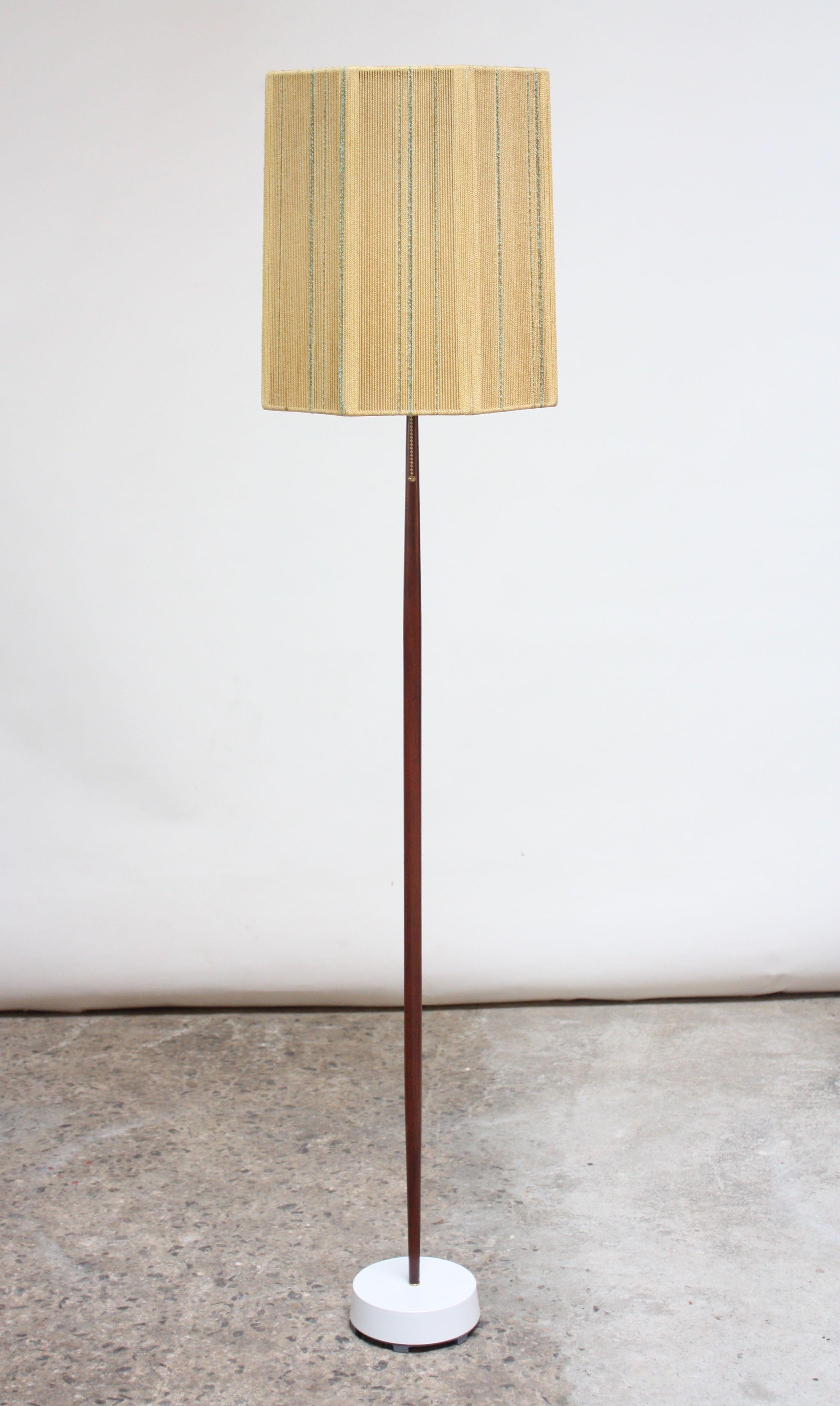 Elegant Scandinavian sculpted-teak floor lamp on painted metal base with brass accents paired with a woven rope octagonal shade in gold and blue.
Base has been restored, and teak has been refinished. All new wiring and pull string on / off switch;
