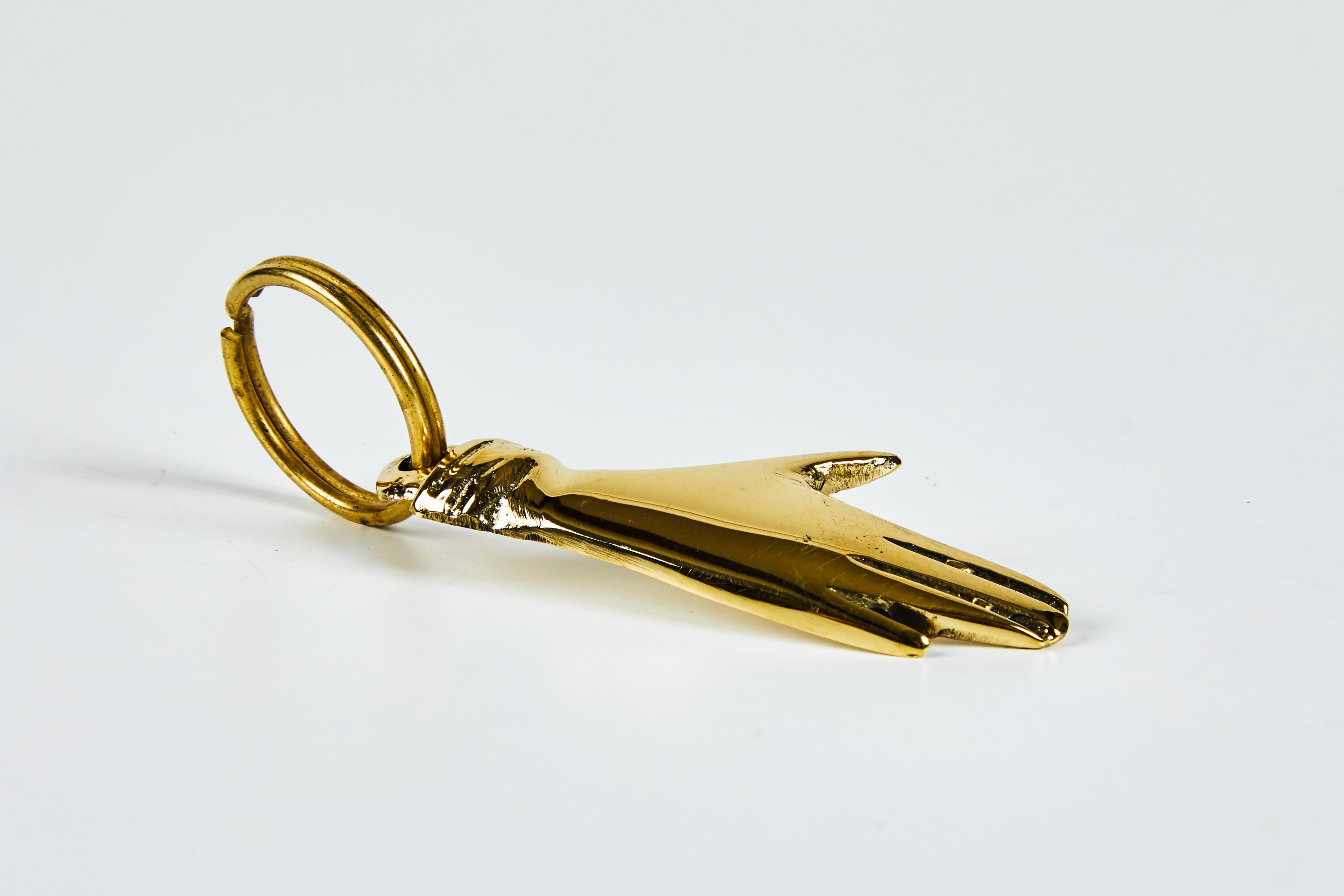 Carl Auböck model #5734 'Hand' brass figurine keyring. Designed in the 1950s, this incredibly refined and sculptural object is hand fabricated in polished brass. 

Price is per item. One in stock ready to ship. Available in unlimited quantities.