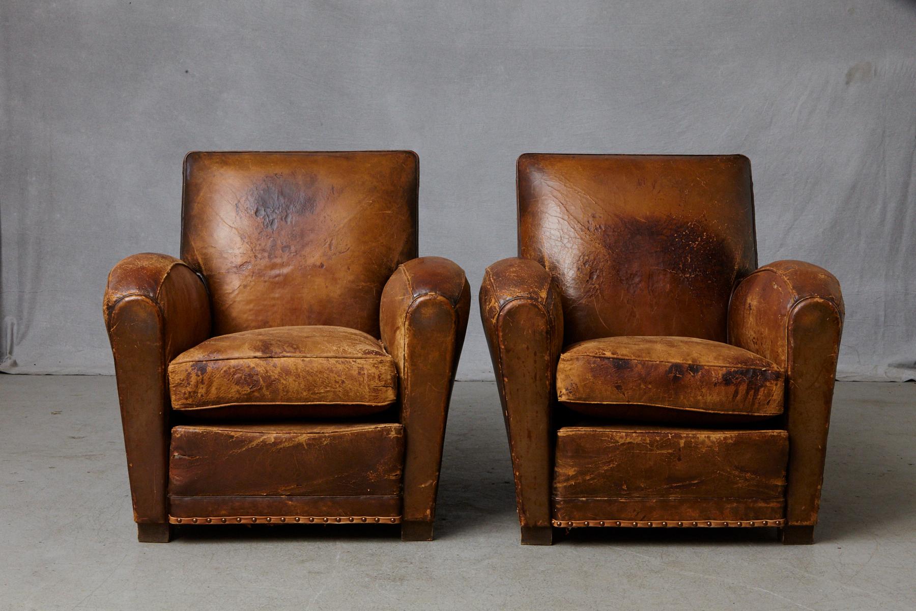 Beautifully distressed and very comfortable pair of French leather fauteuils or club chairs, circa 1930s.
A few tears, repairs and rips on both chairs. Please refer to the detailed photos, as they are part of the description. Solid frame work. Very