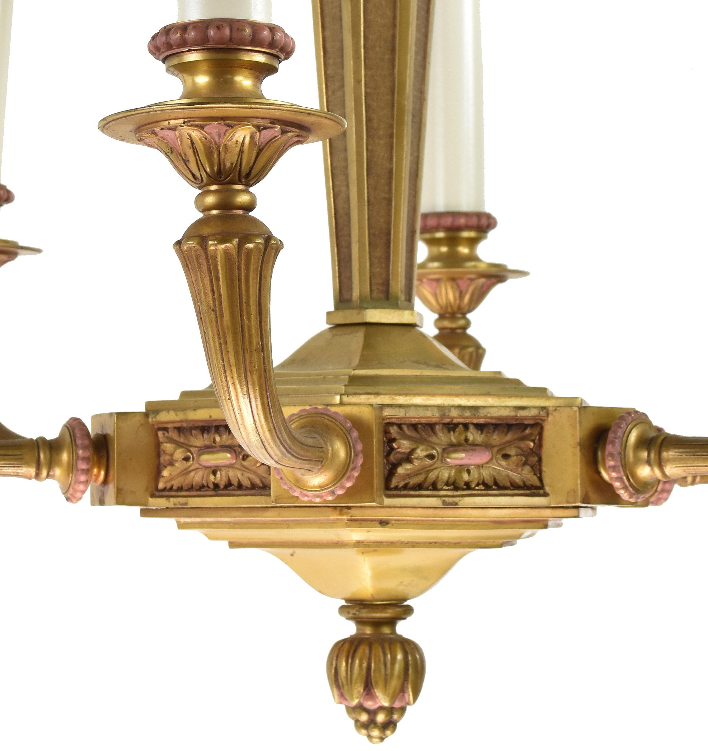 Elegant six candle cast brass chandelier with sweeping arms and leafy details throughout the fixture’s body. Subtle, soft pink accents meld seamlessly with the warm brass, creating a rich blanket of color,

circa 1920.
Condition: Very good 
Finish: