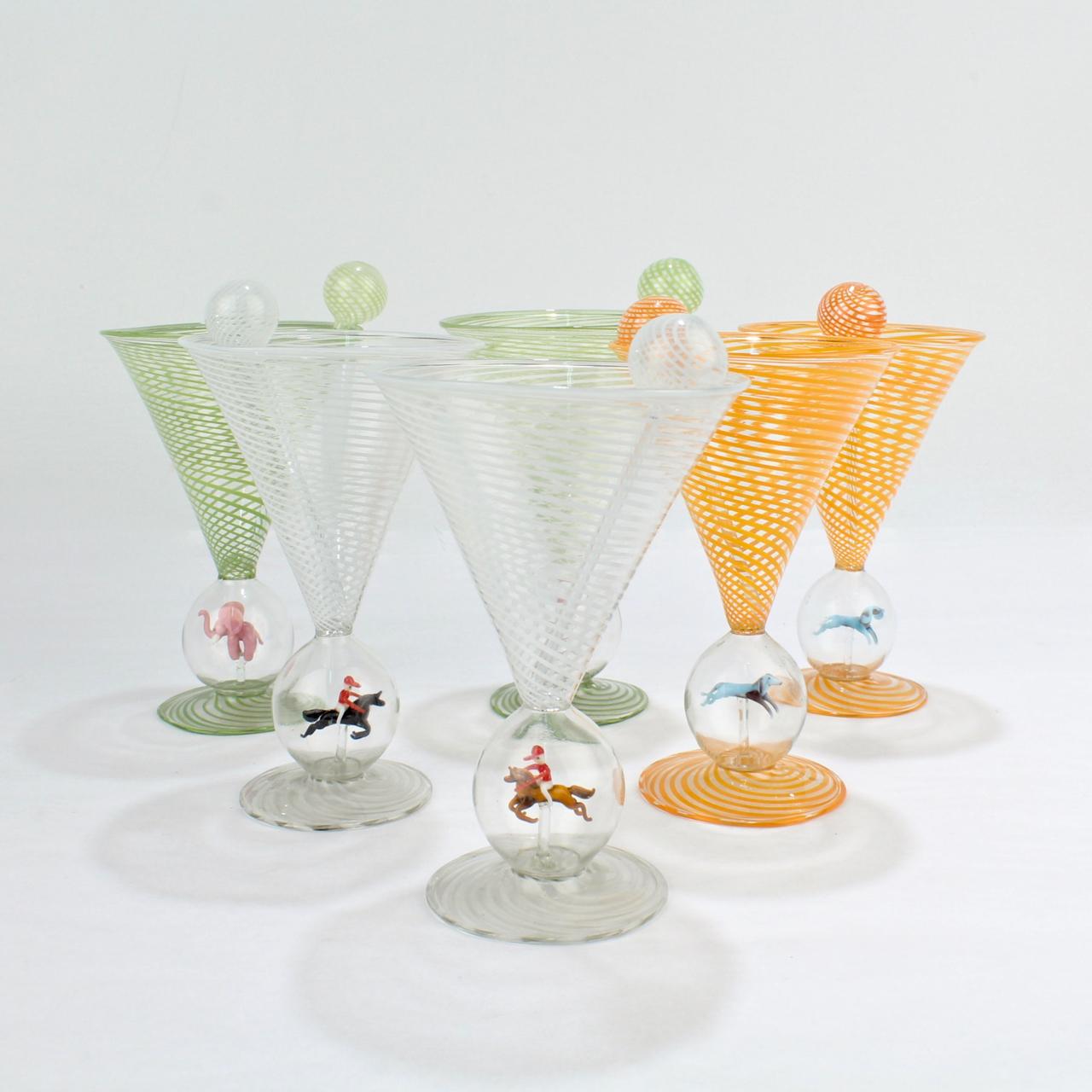 A set of 6 fine Bimini type martini or cocktail glasses.

Each glass is designed in the Art Deco style and has a fine lamp work figure enclosed in its stem. In this set, there are 2 examples of a dog, an elephant, and a horse and jockey.

Each