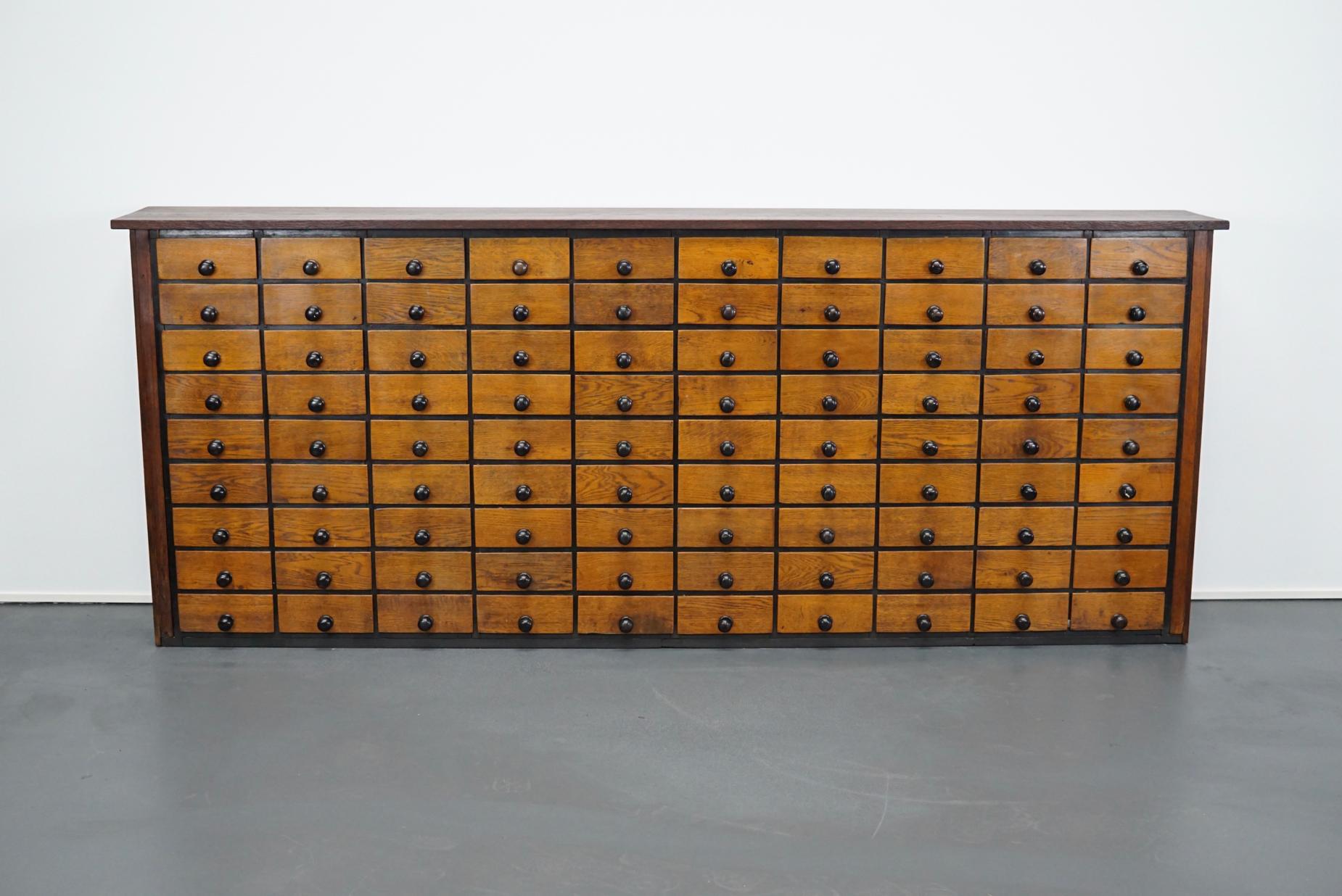 This apothecary cabinet was designed during the 1930s in the Netherlands. The piece features 90 drawers with iron hardware. It remains in a very good restored condition with signs of use and age.

The inside measurements of the drawers are: L 22.5