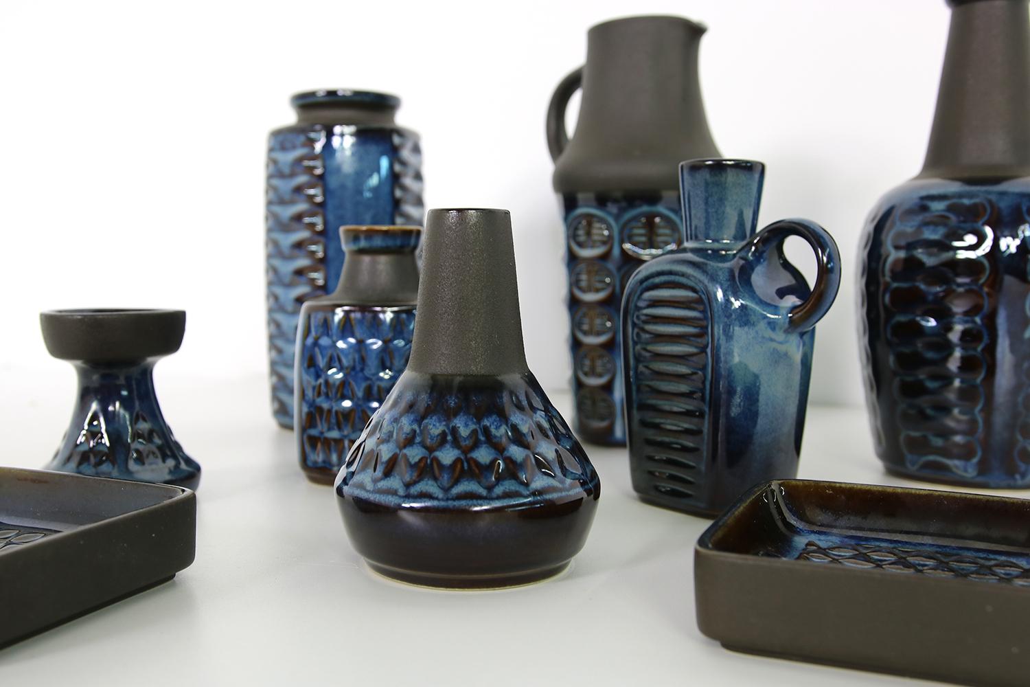 Beautiful set of nine (9) pieces, vases and bowls, collector's condition, beautiful, blue glaze mixed with matt black, beautiful pottery art.
Six vases, one candle stick holder, two bowls. 
The vases are 26, 25, 22, 16, 2x 13, 9cm high, the bowls
