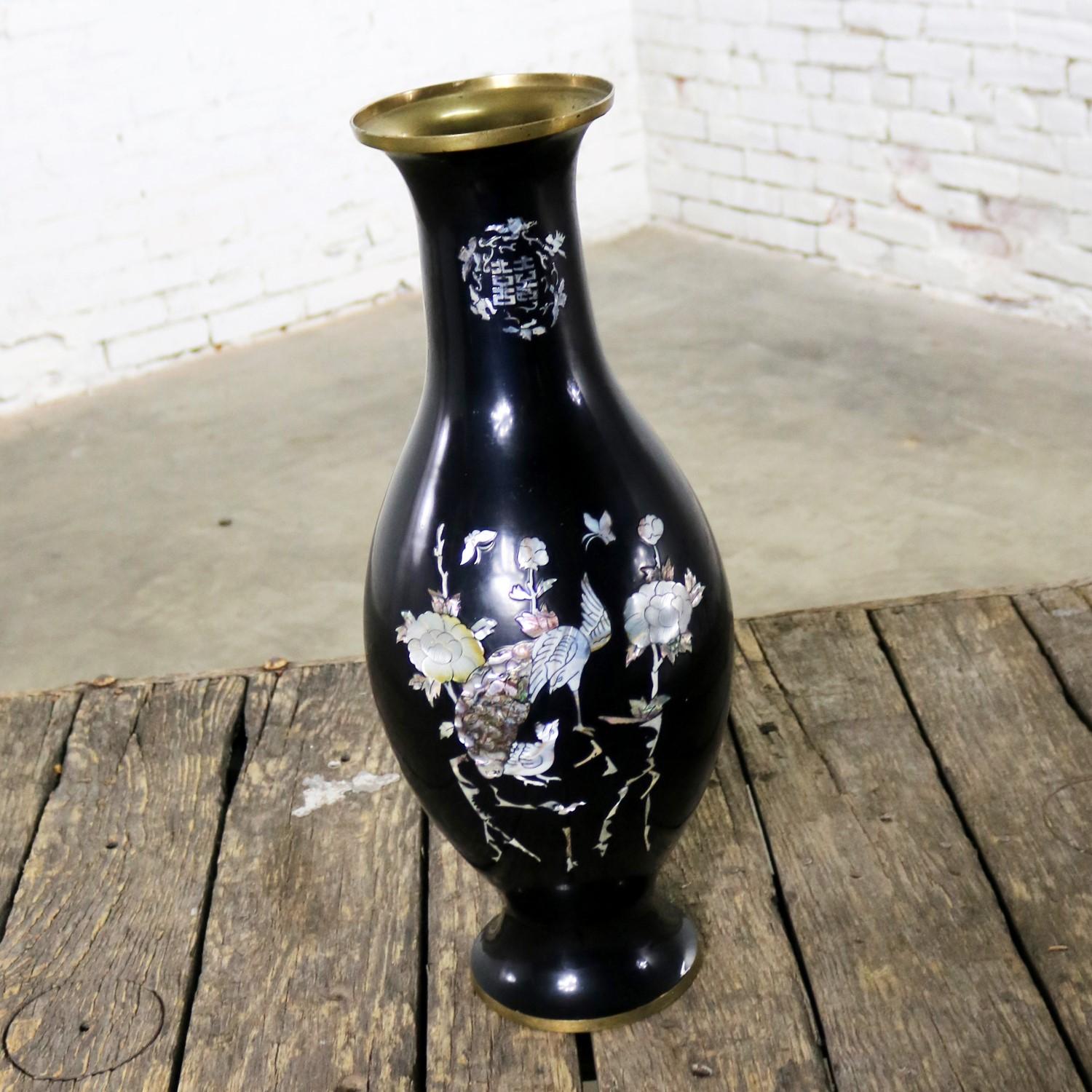 Beautiful vintage extra-large black lacquer over brass Korean bottle shaped vase footed and inlaid with mother-of-pearl birds, butterflies, and flowers. It is in wonderful condition. There is no loss to the mother-of-pearl. However, there are a few