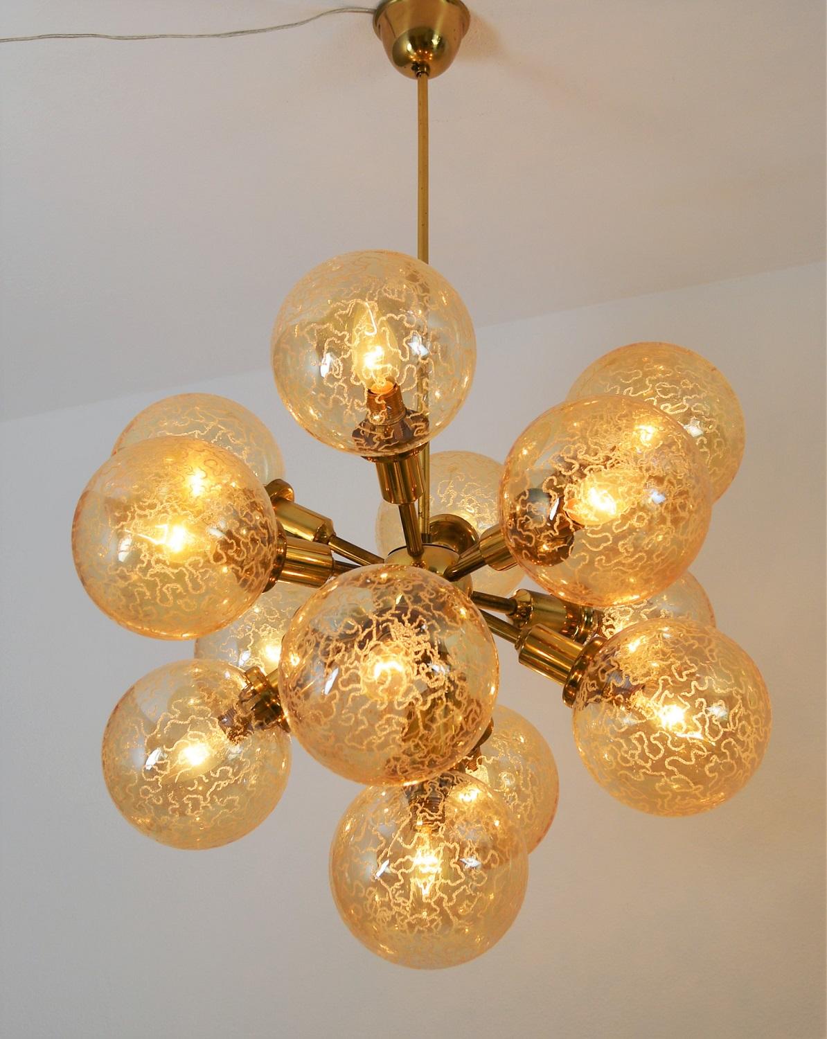 Magnificent pair of Sputnik chandeliers with shiny brass frame and gorgeous glass 13 glass spheres.
Made in Austria during the 1960s.
The glasses are in amber or honey color with bizzarre pattern. The diameter of one glass sphere is 5.9 in or 15