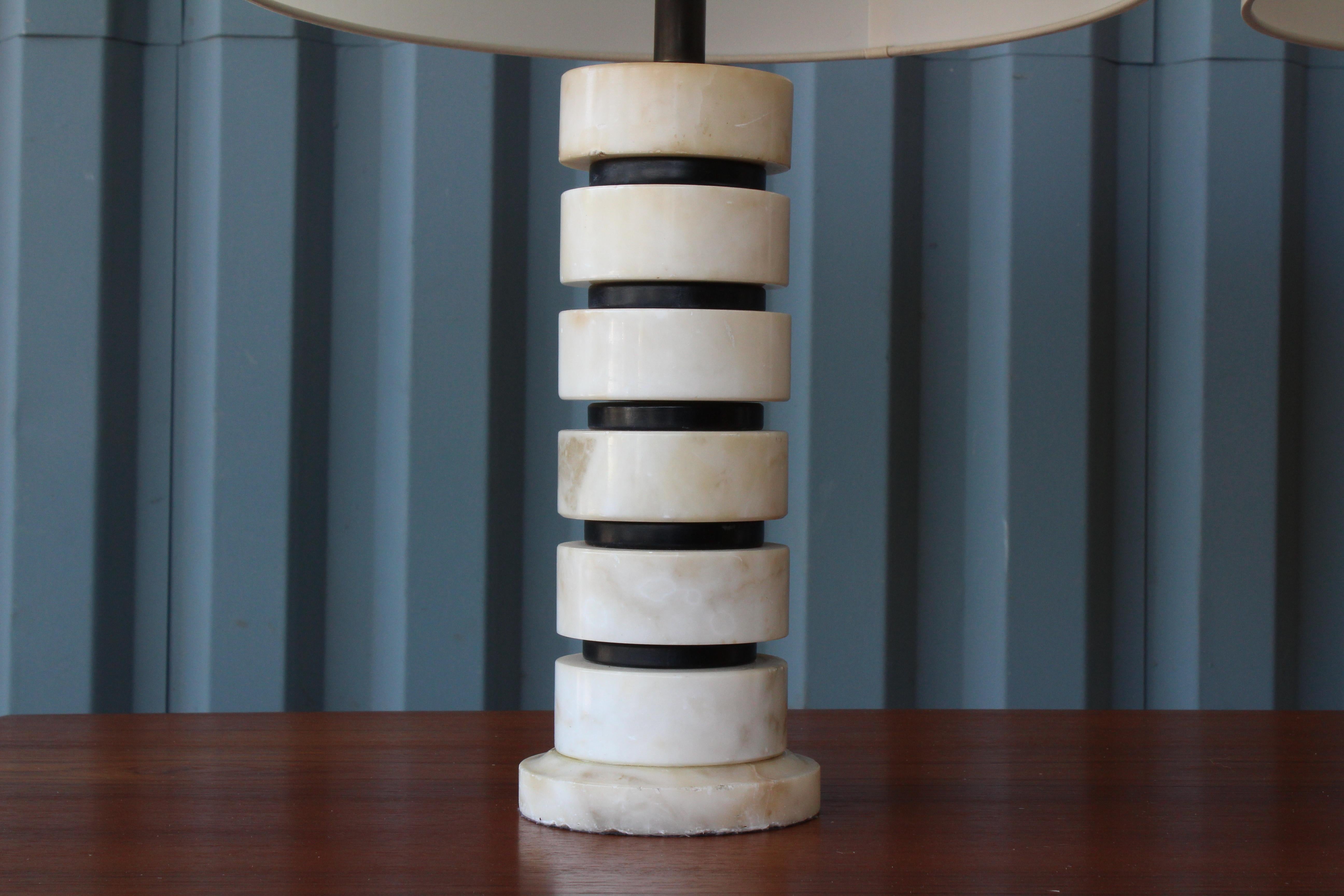 1970s Italian table lamps made of stacked marble with ebonized wood between each piece. Recently rewired and fitted with custom silk shades with top diffusers. Pair available, priced individually.