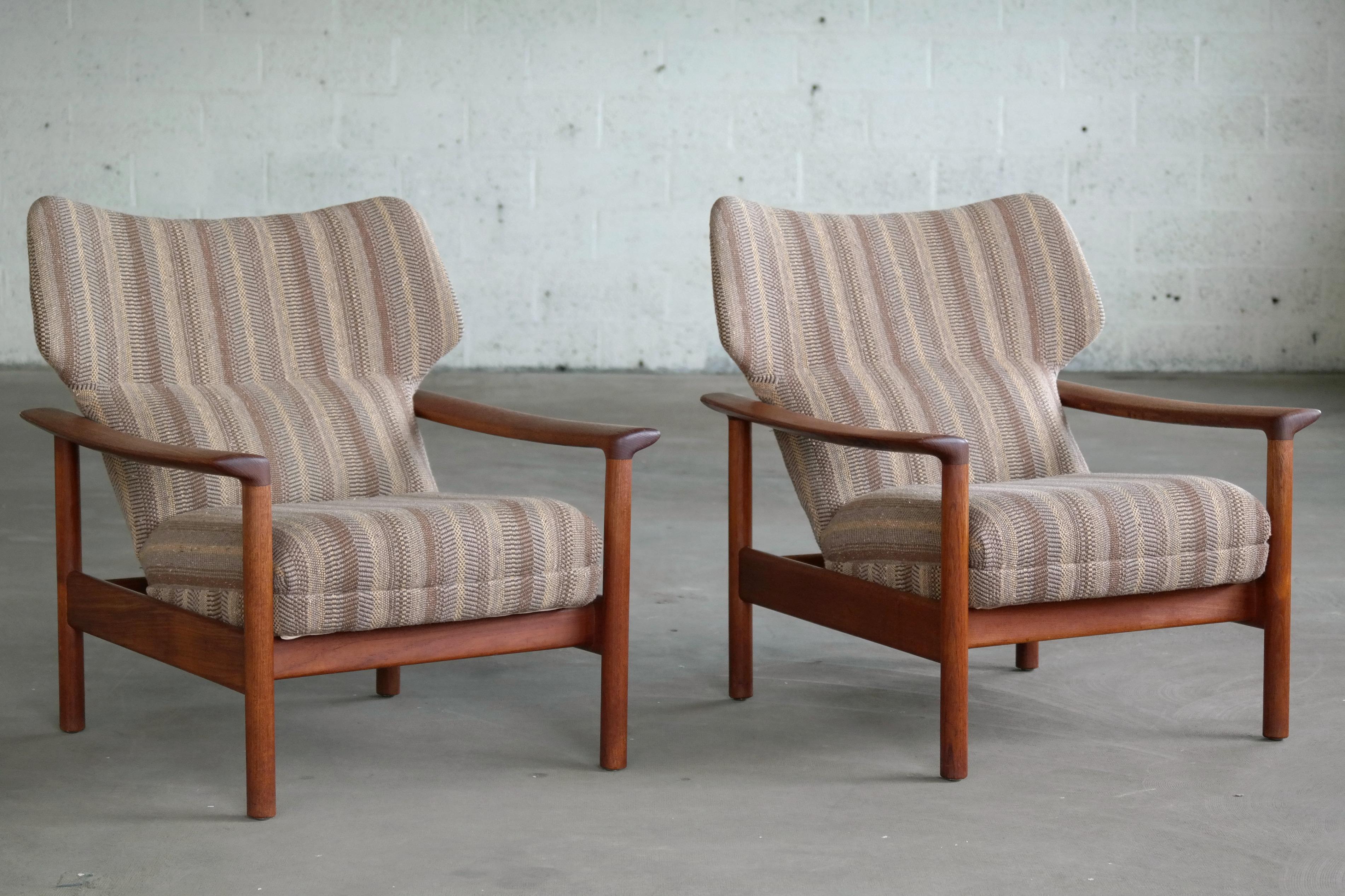 Fantastic pair of very comfortable classic easy chairs in teak and wool. The dimensions of are slightly more generous than the traditional 1950s designs and made from solid teak indicating a production from the early 1970s. They are unmarked but of