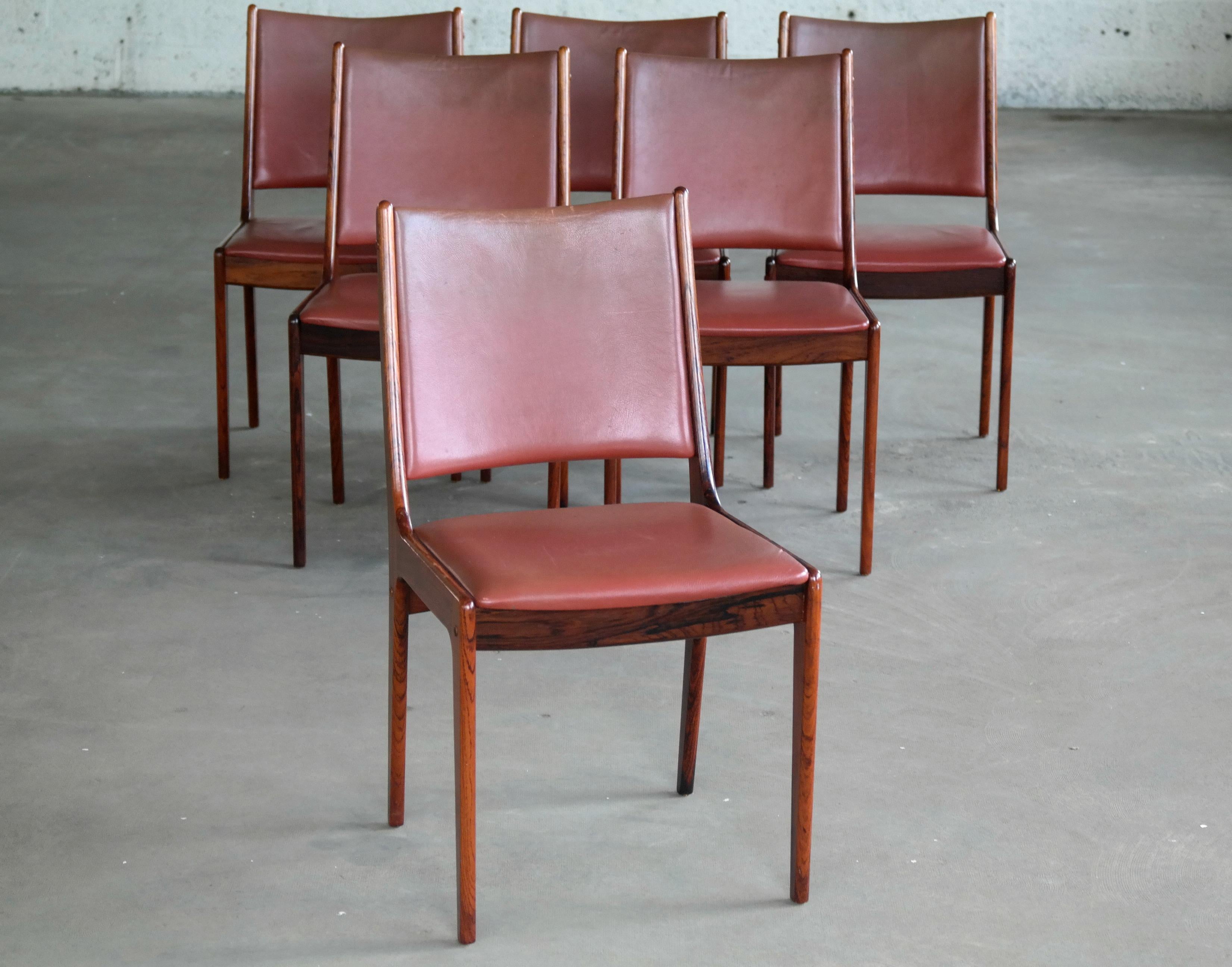 Beautiful set of six dining chairs in solid rosewood with leather covered seat and backrest designed by Johs Andersen for Uldum in the late 1960s. Classic light elegant Danish design. Overall very good to excellent condition with a couple of chairs