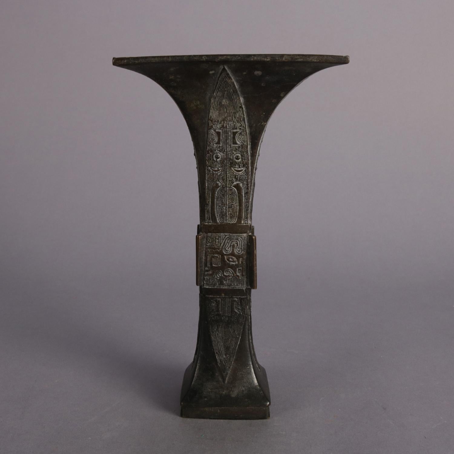 Antique Chinese tribal vase features bronzed metal flared trumpet form construction with reserves having incised tribal symbols, 19th century.

Measures: 8.5