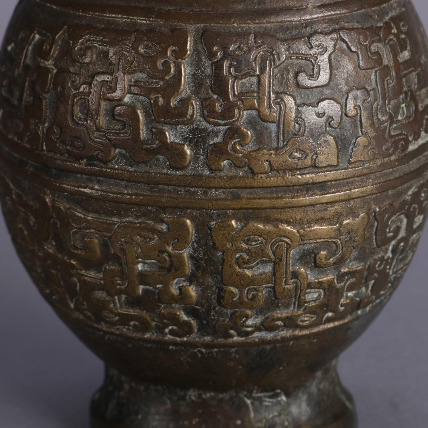 Antique Chinese vase features bronzed cast metal vase features bulbous form with double chicken head form handles, stylized scroll form heart collar and central band with stylized figures and symbols, circa 1900.

Measures: 9.25