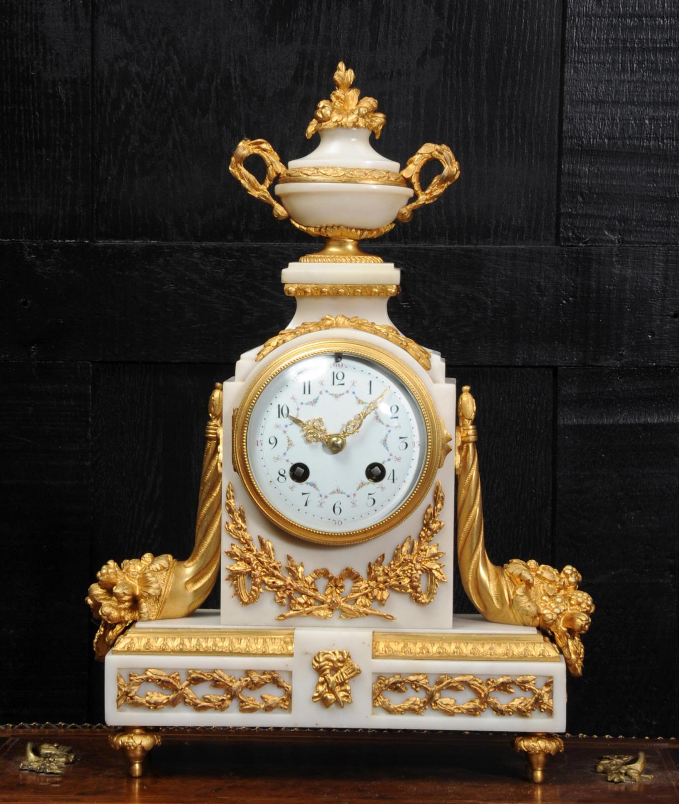 A beautiful antique French classical white marble boudoir clock by the famous maker Samuel Marti. The silky white marble is mounted with crisply modelled and finely gilded bronze. To the sides are cornucopia, an urn to the top and fretted laurel