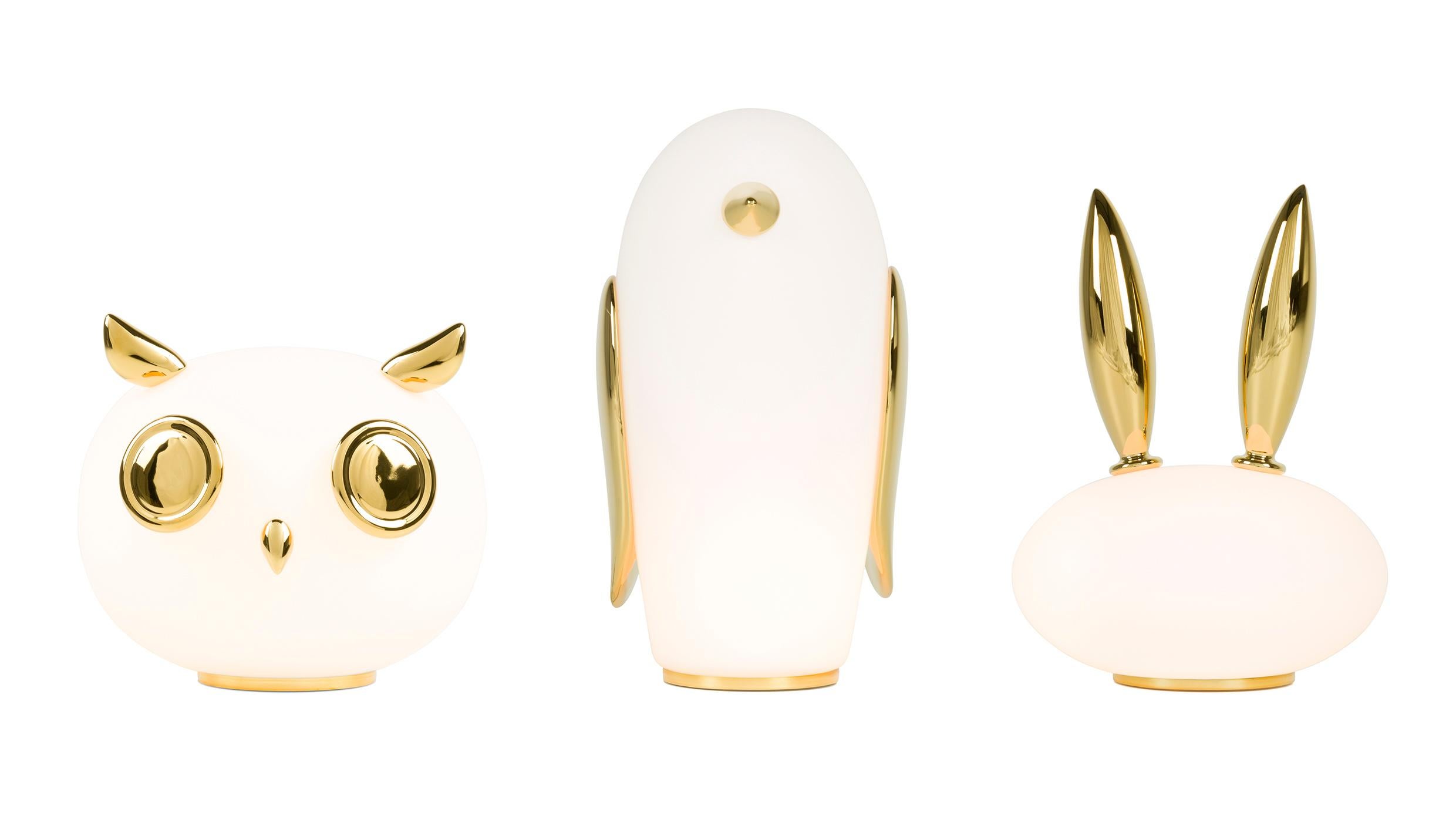 Uhuh, Purr & Noot Noot (owl, rabbit & penguin) are a series of table lamps by Marcel Wanders with their very own personalities and characteristics. They are produced in white opal glass with ornamentation in gold painted ceramic. The Lamps are