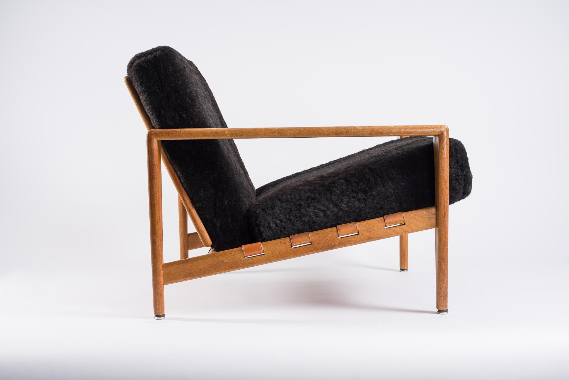 Oak Swedish lounge chairs.
Pair of armchairs newly upholstered with black lambskin and leather ties.
Leather in very good conditions without cracks.
Bodö easy chair from AB Hjertquist & Nässjö
Designed by Svante Skogh in 1957.
 