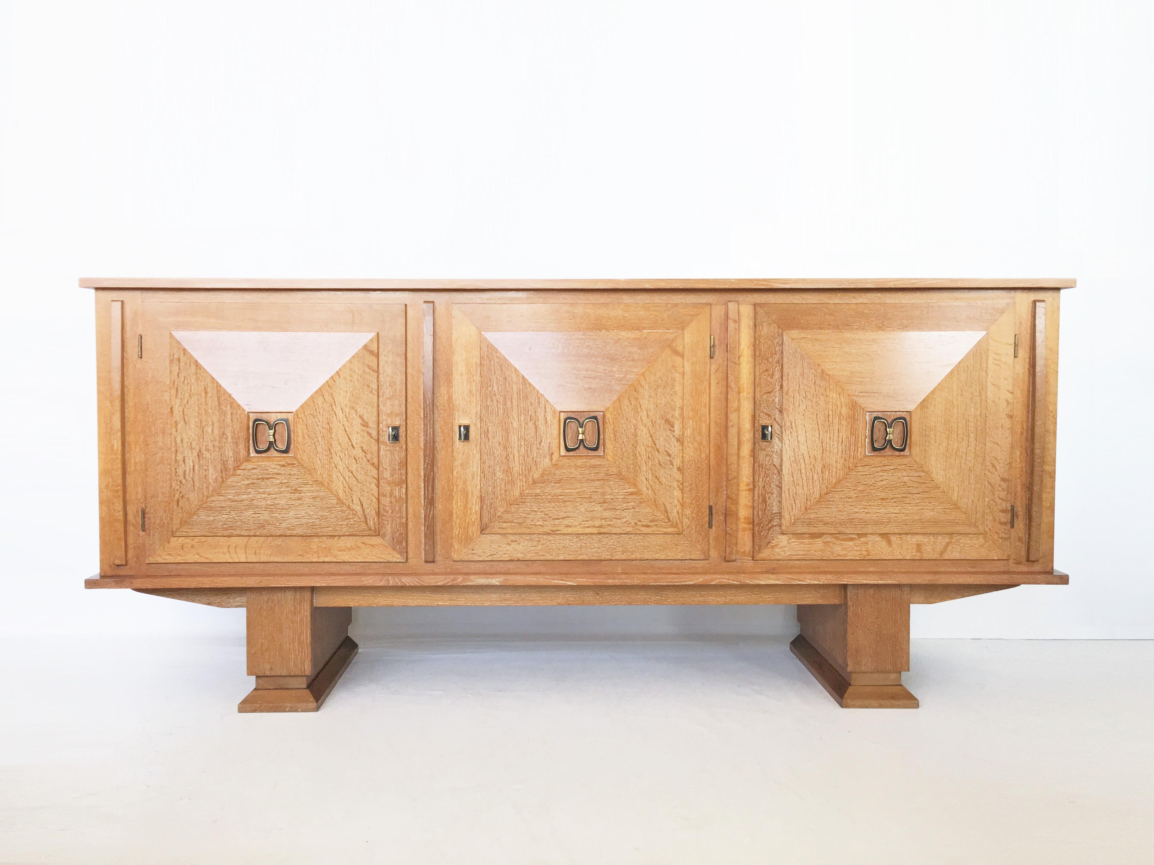 Very well crafted sideboard or buffet in oak, showing an overall white wash look with brass details. Three doors, all with beautifully designed wooden graphical patterns. The diagonal lines with added squares and a frame emphasize the