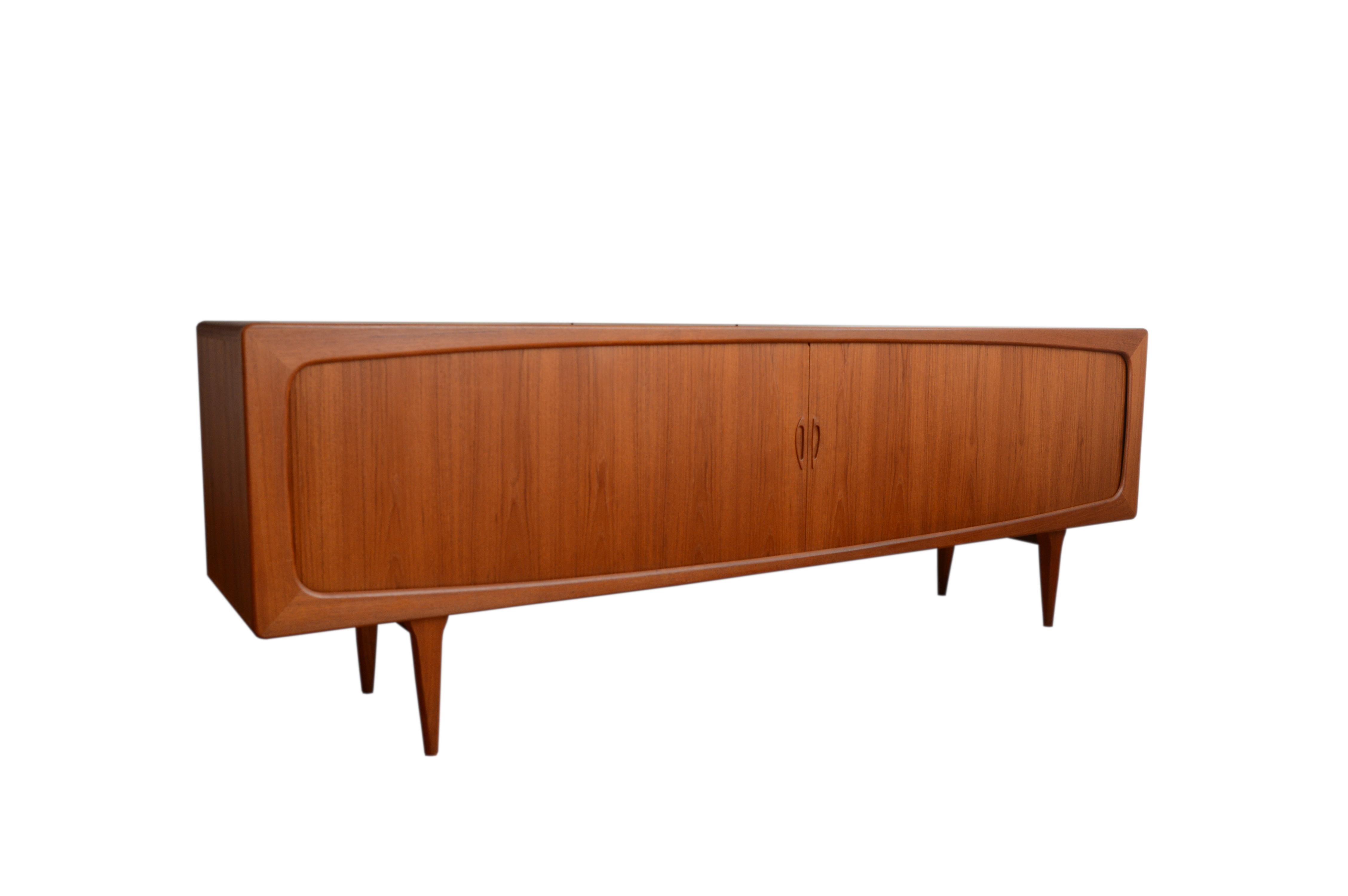 A Danish teak sideboard designed by Hans Peter Hansen and produced by Skive Mobelfabrik. This impressive very long credenza features organically shaped body with rounded corners that rests on four tapered legs. Veneered in teak of beautiful and even