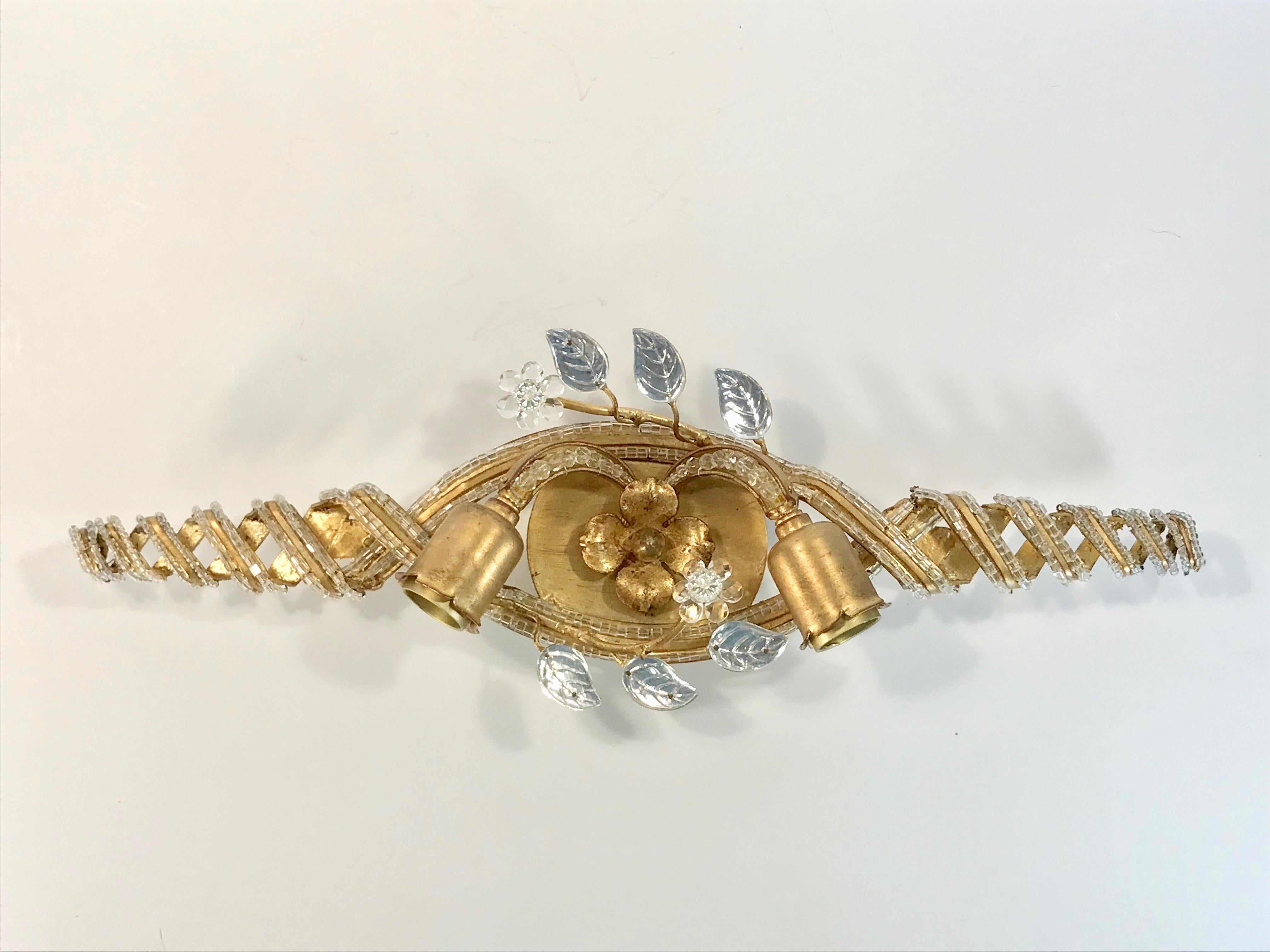 A single gilt metal and glass beaded wall sconce with decorative glass leaves and flowers. Perfect for over a bathroom mirror, this sconce uses two - A or Edison base bulbs and has been rewired for US installations. Retains original brass 
