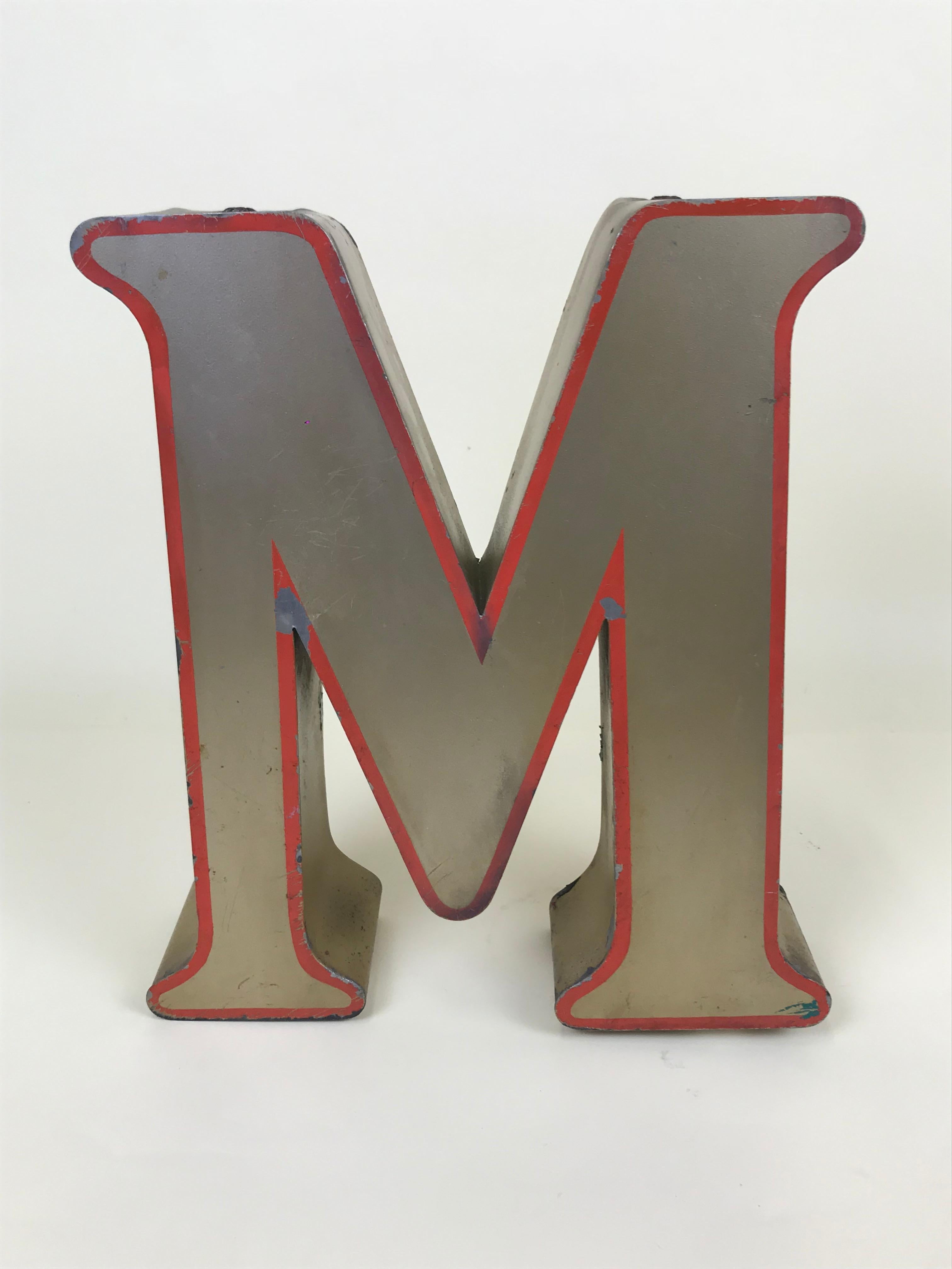 1970s large English vintage metal capital letter M in bronze color with red profile.
 