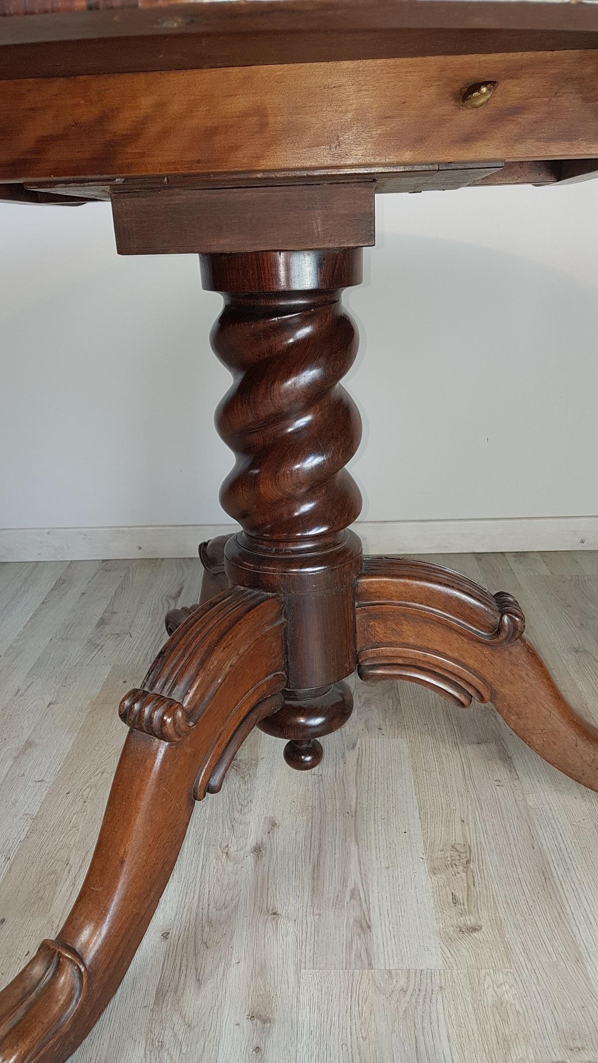Beautiful important antique table made in the mid-1800s in mahogany. Veneered strip to create contrasting wood grain. Table with elegant turned central leg, the top is characterized by a narrow and comfortable band at the seat. The particularity of