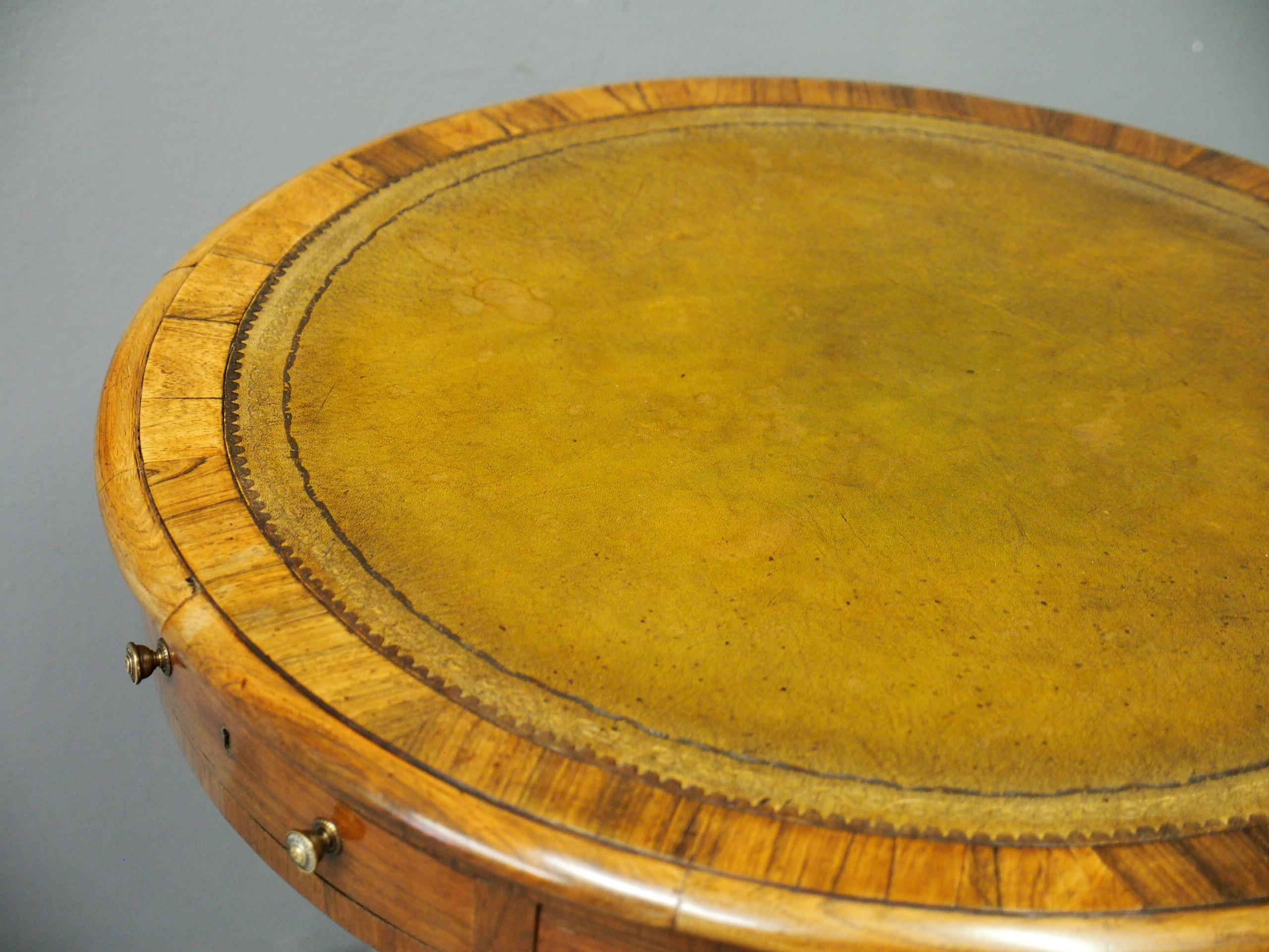 George IV rosewood and leather top drum or rent table of diminutive proportions, circa 1830. With a gilded and tooled green leather insert to the top, contained in a circular bezel of crossbanded rosewood, with an ogee moulding. The apron has a