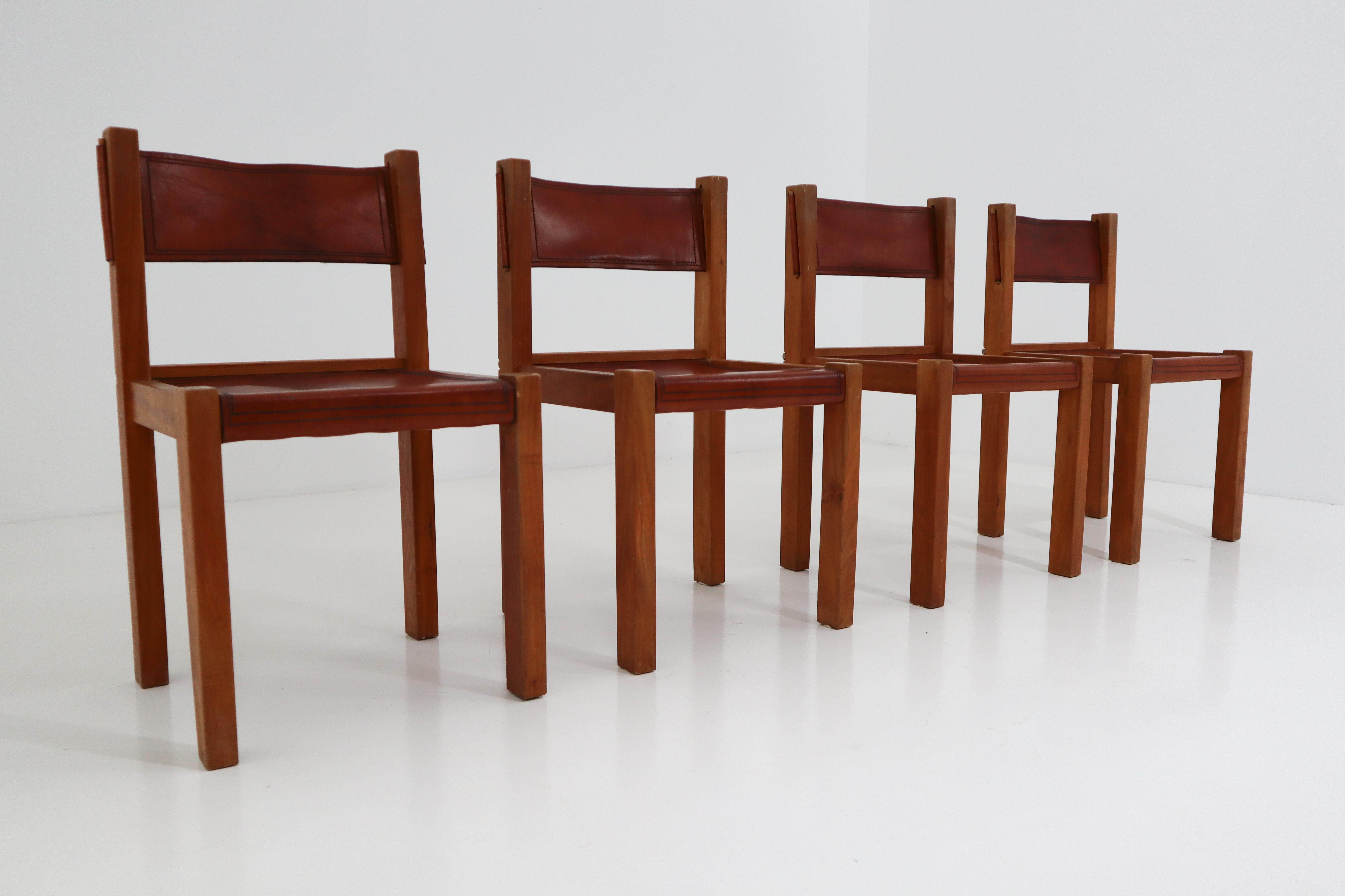 Set of four leather and elmwood dining chairs. Made in France, 1960s.