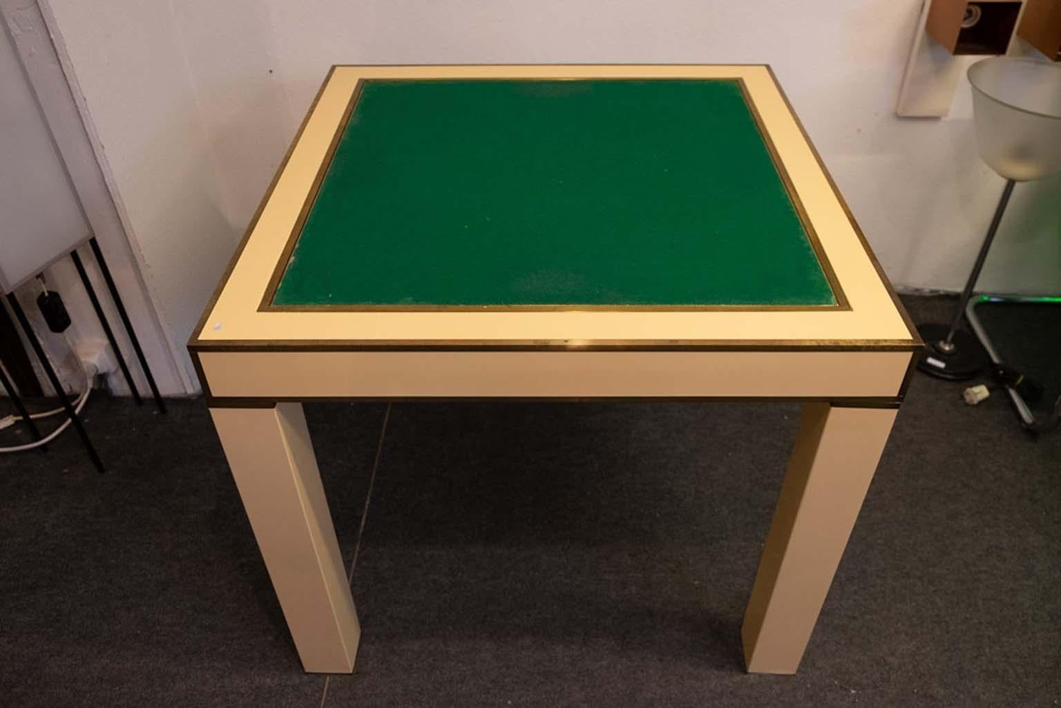 Lacquered ivory and brass game table designed by Jean-Claude Mahey for the Maison Romeo in the 1970s.
This table was produced only on request and in very limited numbers. The chess board is removable and reveals a backgammon game, or can be flipped